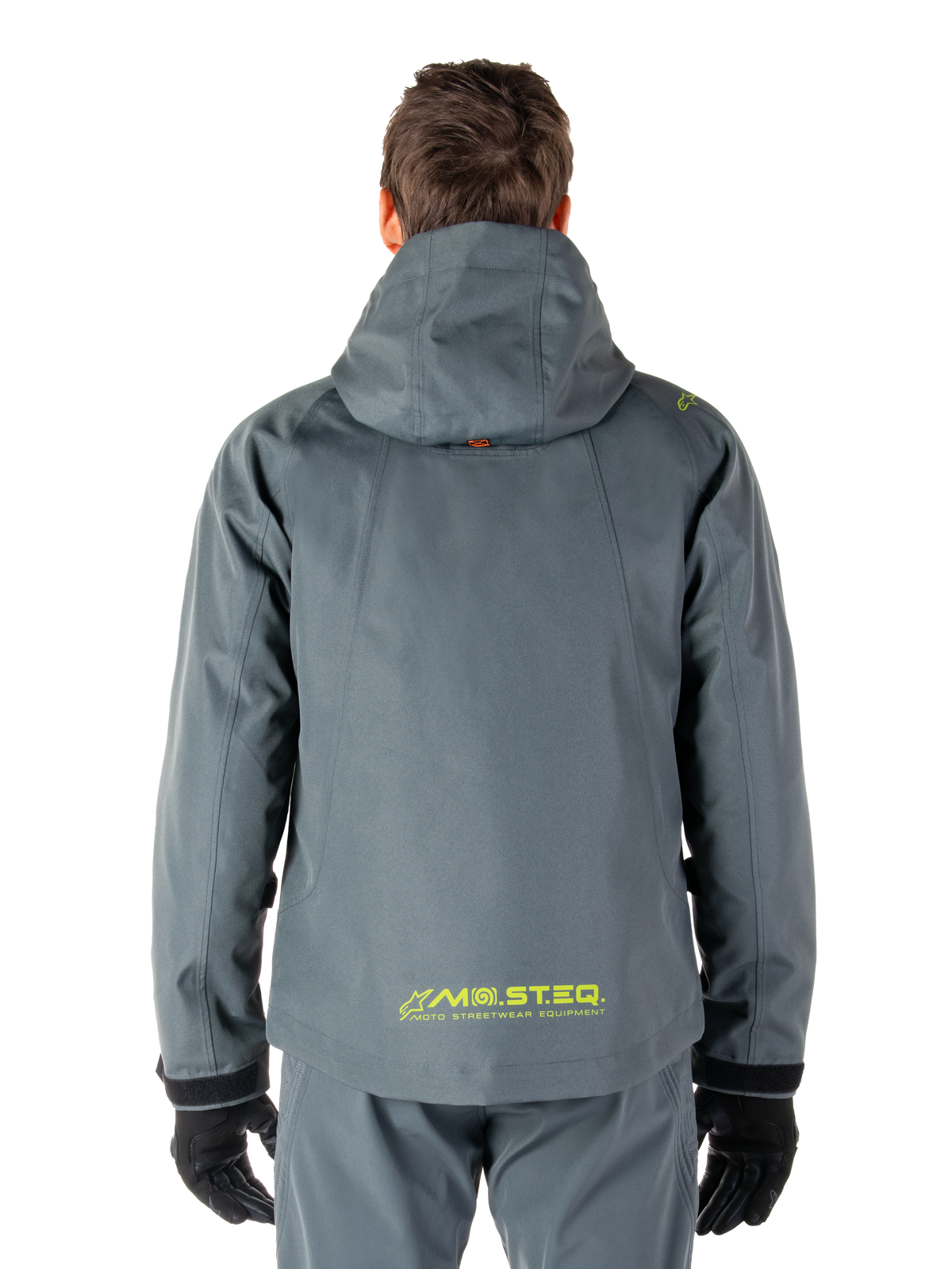 Alpinestars Morush Wasserdichter Parka, Motorradjacke, Urban-Grau, Rückansicht mit Kapuzendesign und gelbem MO.ST.EQ. Logo am unteren Rücken, moderne, von urbaner Streetwear inspirierte Motorradausrüstung