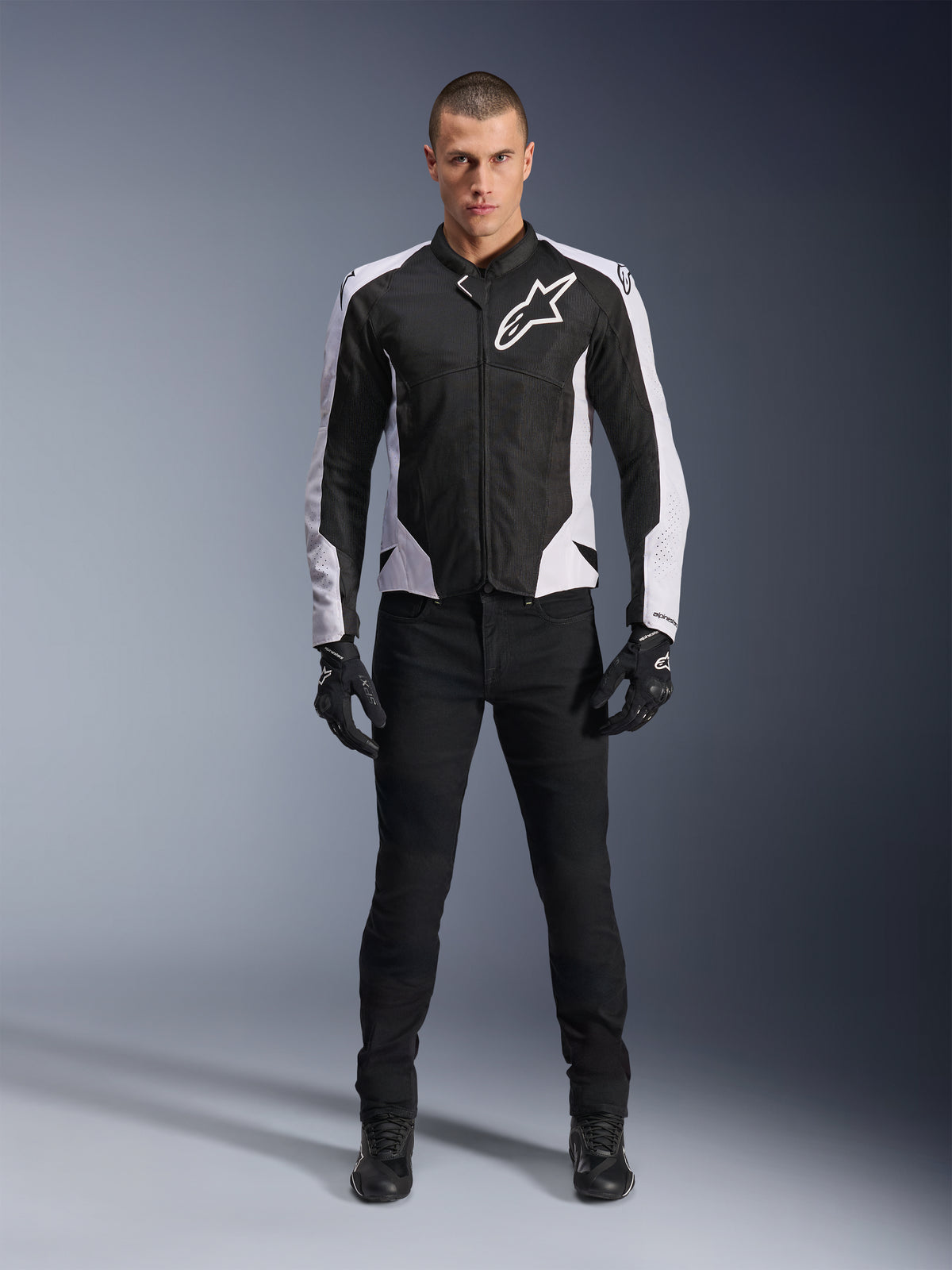Alpinestars Viper Air V4 Jacket, Black and White motorcycle jacket with large white logo on chest, worn by a male model with black pants and gloves, featuring mesh panels for ventilation, sporty road riding apparel