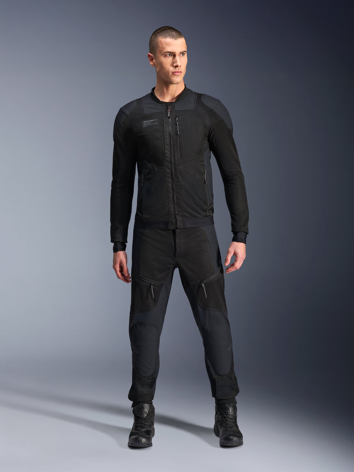Alpinestars Troop-Air Pro Jacke, schwarze technische gepanzerte Motorradjacke, mit Mesh-Einsätzen und Frontreißverschlüssen, getragen mit passender schwarzer Hose und Motorradstiefeln, hochwertige urbane Straßenausrüstung