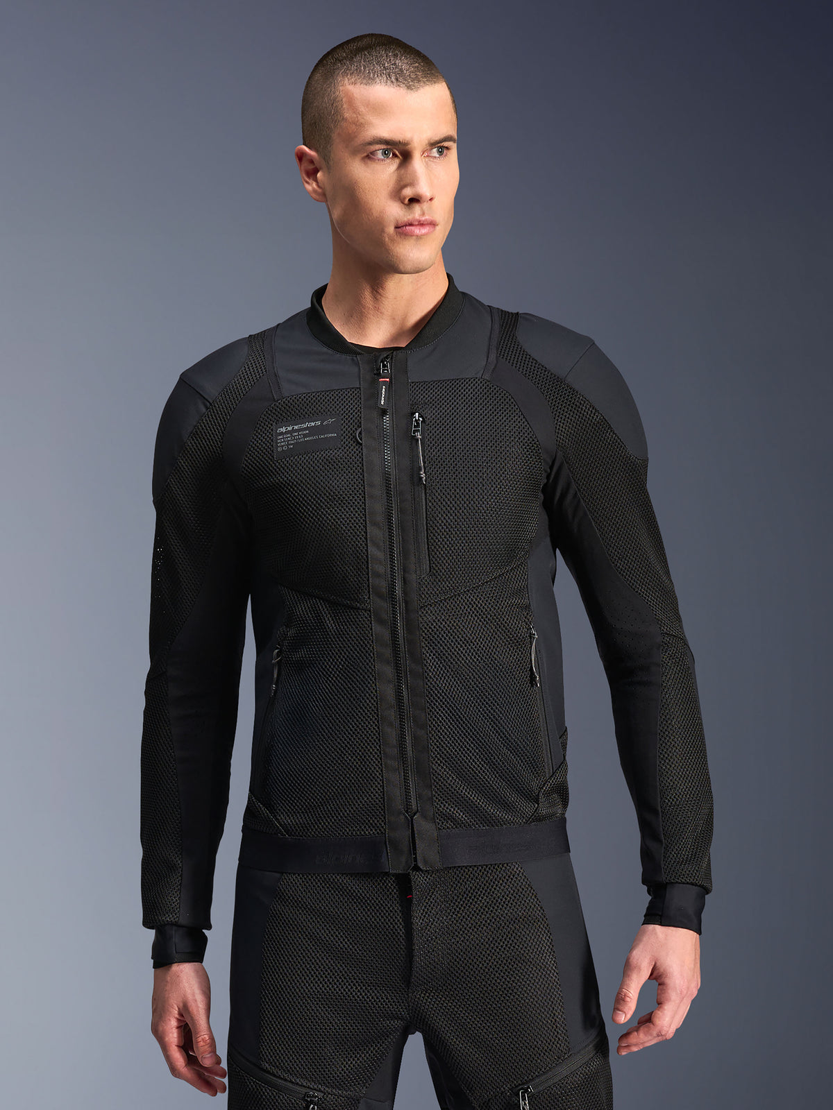 Alpinestars Troop-Air Pro Jacke, schwarze Motorrad-Mesh-Jacke, männliches Modell in gepanzerter Air-Jacke mit 2D-Tech-Mesh-Struktur, Frontreißverschluss, Reißverschlusstaschen, technische Performance-Fahrausrüstung