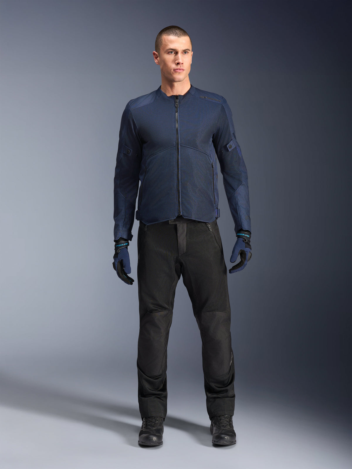 Alpinestars C-1 Air Jas, blauwe urban herenmotorjas met tech mesh voor touring, gedragen met een zwarte motorbroek.