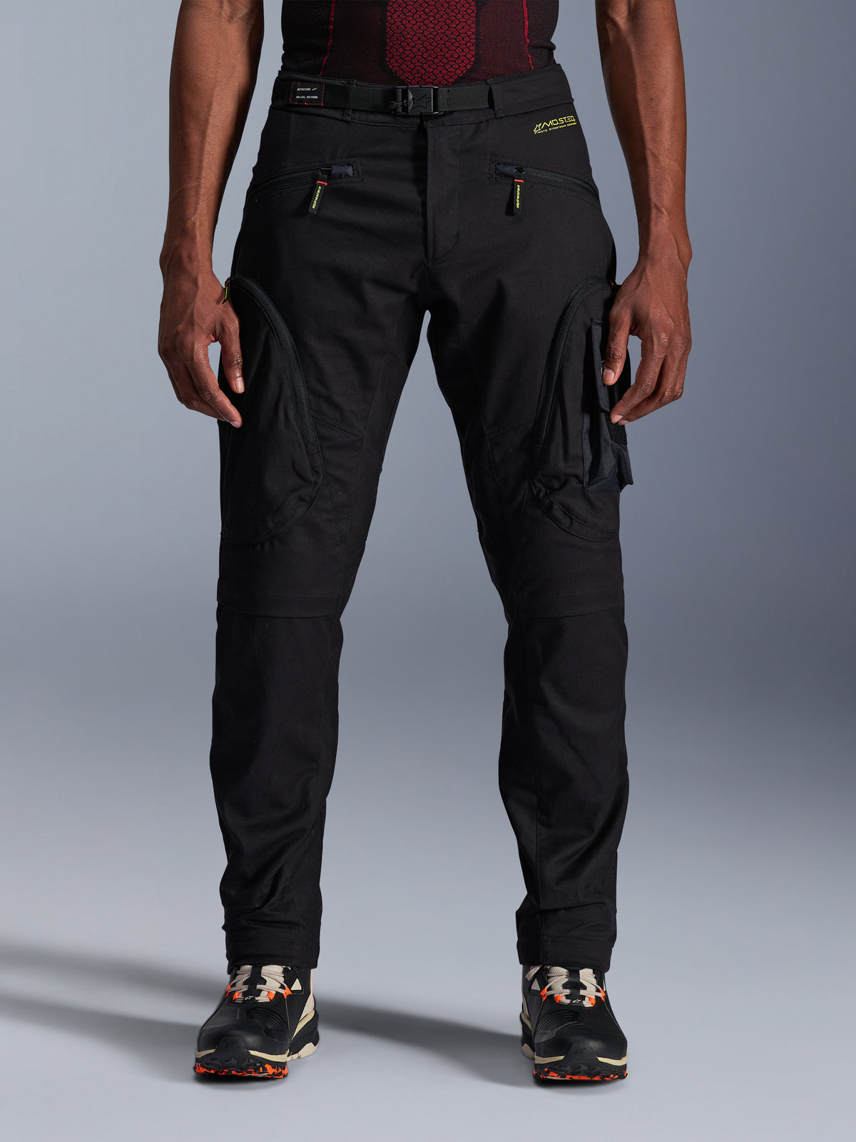 Alpinestars Acteon broek, zwarte urban motorbroek, taps toelopende regular fit met zij-cargozakken voorzien van omgekeerde spiraalritsen, geïntegreerde tailleband en gele branding, beschermende textiele motoruitrusting
