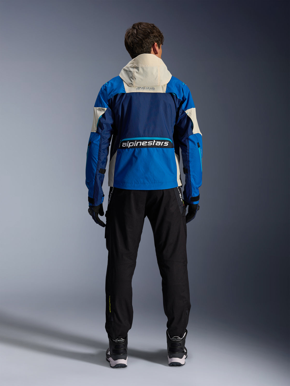 Alpinestars Mogress Air jas, heren-urbanmotorjas, blauw en almond, ripstop achterkant, CE-gecertificeerd, achteraanzicht met capuchon.