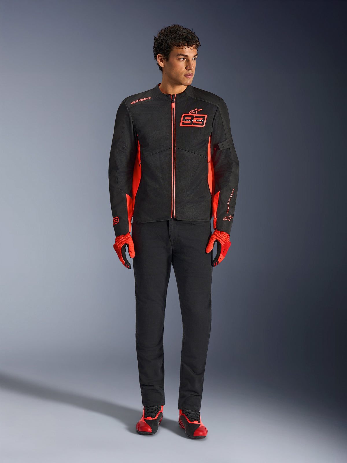 Alpinestars MM93 C-1 Air Jacket, Motorcycle Jacket, Black and Red Fluo, featuring Marc Marquez branding and 93 logo, worn by model with matching red gloves and black pants, lightweight textile and mesh construction for urban riding