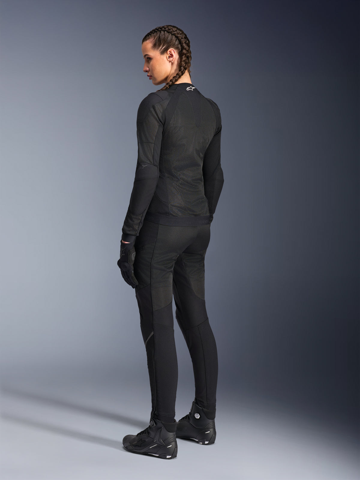 Veste Alpinestars Stella Troop-Air pour femme, noire, vue de dos, portée avec un pantalon de moto, des gants et des bottes noirs assortis, construction technique en maille ajustée pour la conduite urbaine