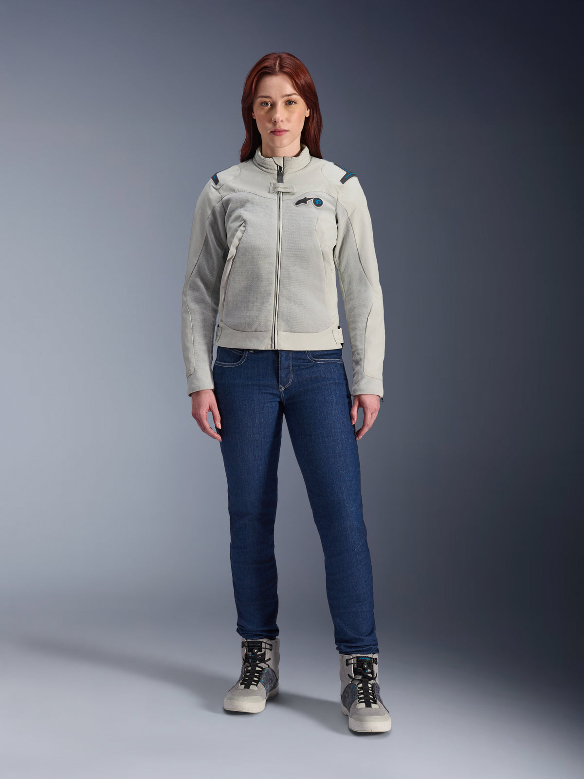 Alpinestars Stella CIRCAL-1 Air Jacket, Women's Motorcycle Jacket, Metal Gray and Methyl Blue, worn with dark blue jeans and gray riding boots, featuring mesh panels for ventilation and a modern urban design