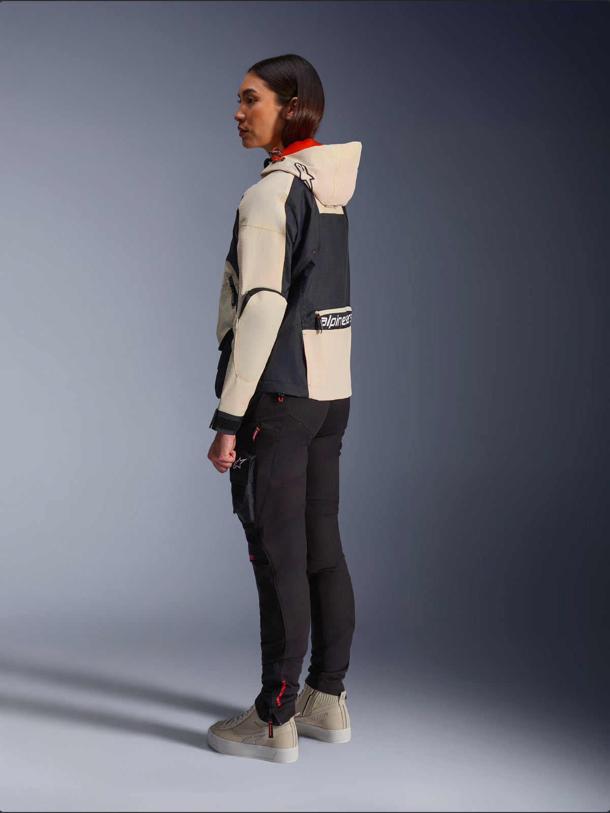 Alpinestars Molly Air Jacket, Women's Motorcycle Jacket, Black Almond, featuring a hooded design with cream sleeves and a black torso, worn with black riding pants and beige sneakers, urban contemporary style.