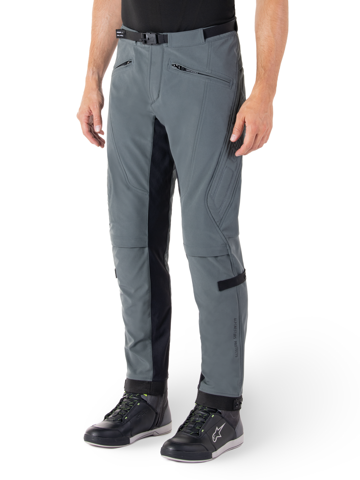 Alpinestars Alden Hose, Motorradhose in Urban Gray und Schwarz, von Streetwear inspirierte Textil-Fahrhose mit 3-lagigem Stretch-Softshell, schwarze Einsätze an den Beininnenseiten, integrierter Taillengürtel, schmale Passform unterhalb des Knies, getragen mit schwarzen Motorradschuhen
