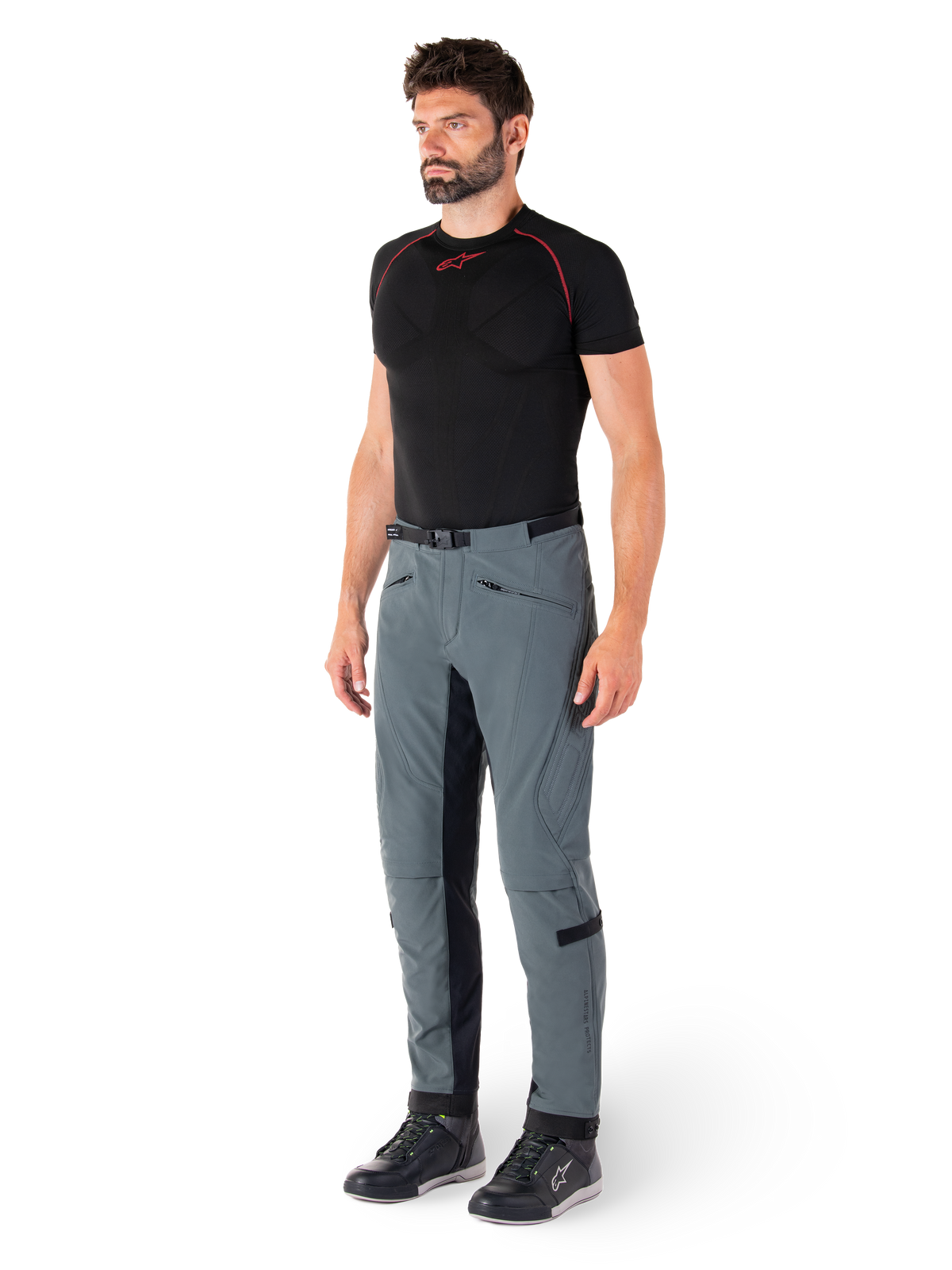 Alpinestars Alden Hose, technische Motorradhose in Urban Gray, mit gesteppten Seiteneinsätzen und schwarzem Stretchmaterial an den Beininnenseiten, kombiniert mit einem schwarzen Base-Layer und Motorradschuhen, Streetwear-inspirierte urbane Motorradausrüstung