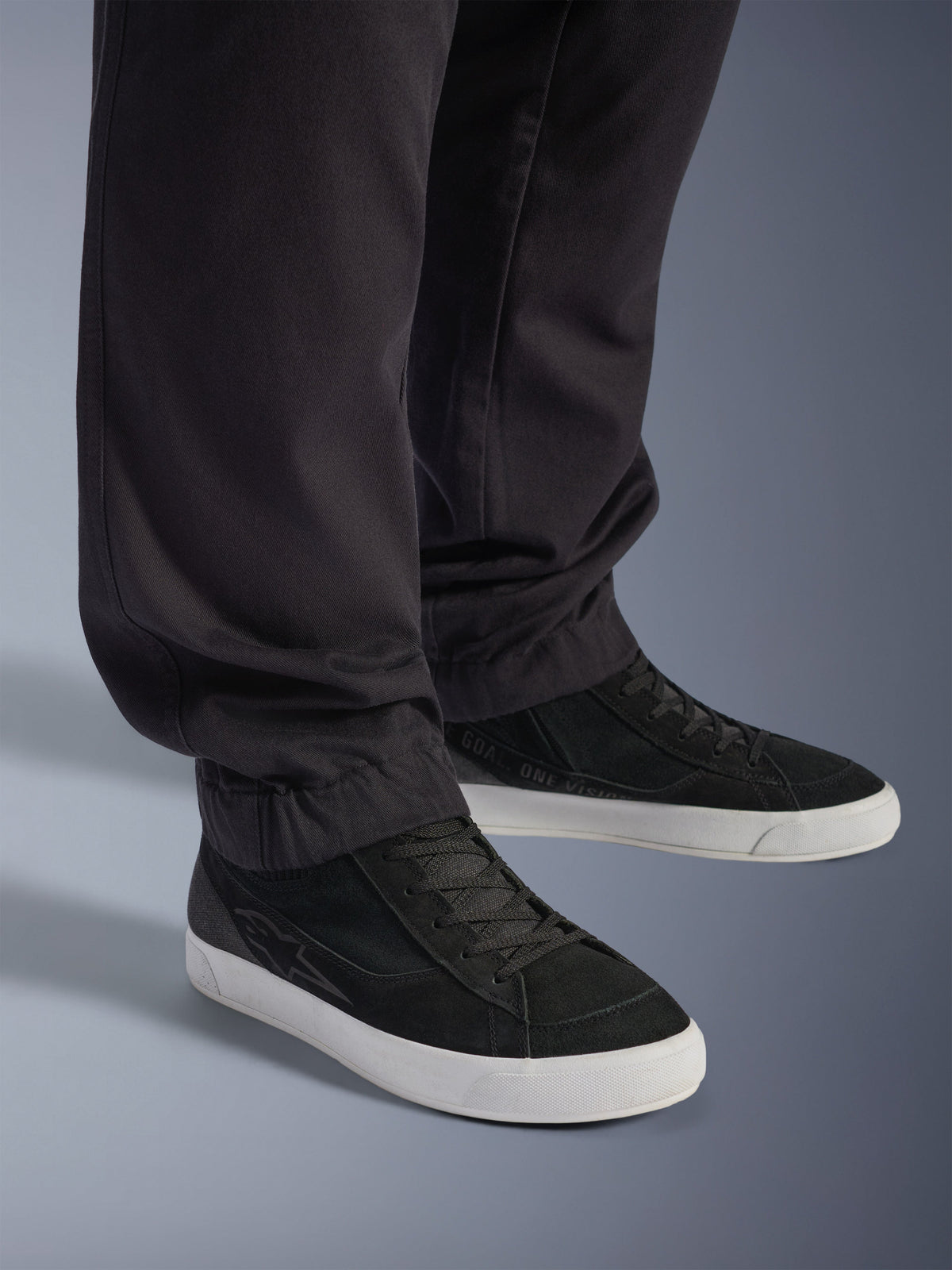 Alpinestars Flex-AST Cargo Broek - Short, stedelijke motorbroek, zwart, voorzien van taps toelopende pijpen met elastische zomen, gecombineerd met zwarte Alpinestars sneakers, eigentijdse urban rijstijl