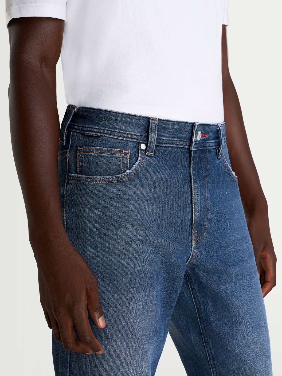 Alpinestars Flex Ast 8 Denim broek, urbane motorjeans voor heren in middelsblauw, close-up van de taille en de voorzakconstructie, gedragen door een model