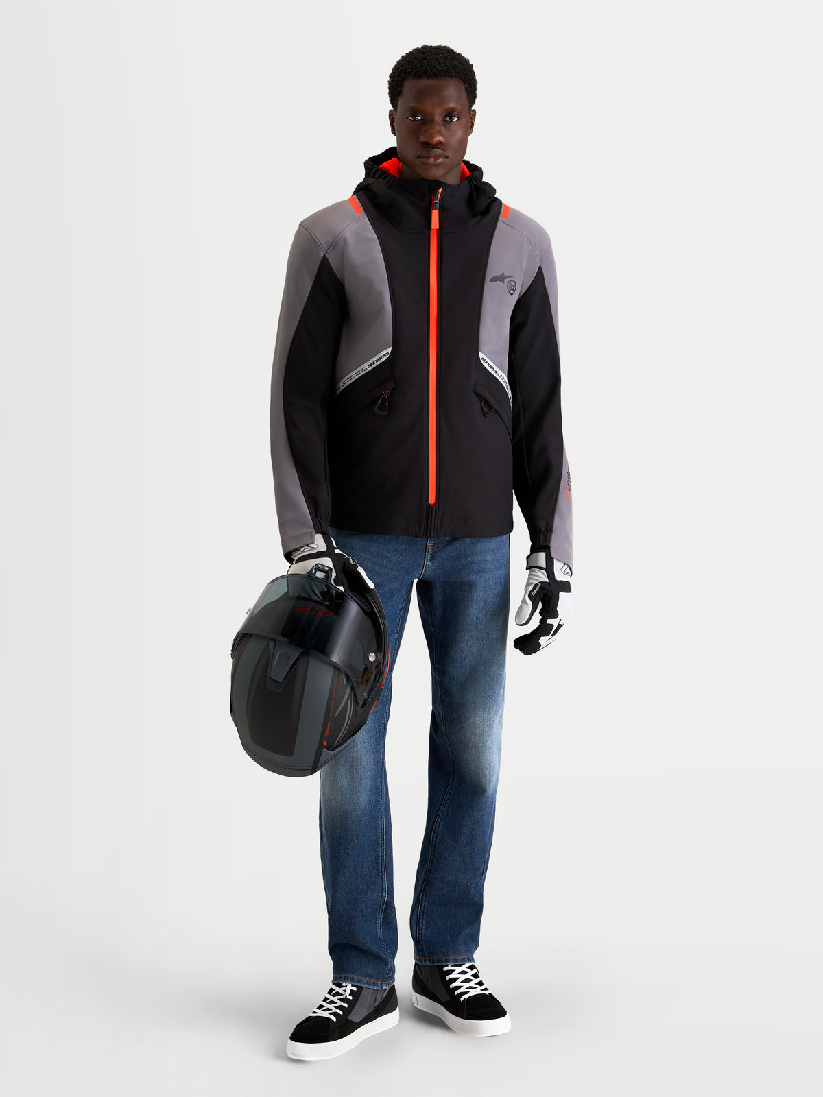 Alpinestars Flex Ast 8 Denim broek, urban motorjeans voor heren in middels blauw, gedragen door een model met een helm en een zwart-grijze technische jas