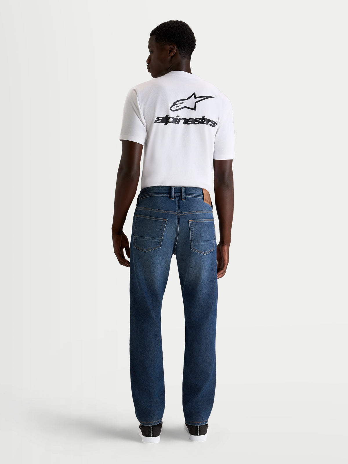 Alpinestars Flex Ast 8 Denim broek Short, urban motorjeans voor heren in middelblauw, achteraanzicht op model met wit t-shirt, AA-gecertificeerde beschermende enkellaags denim met stretchcomfort
