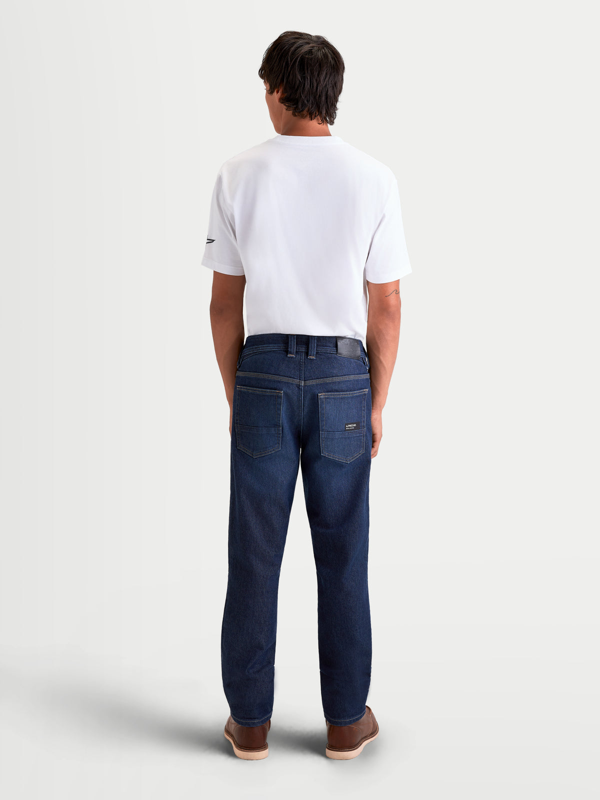 Alpinestars Flex Ast 7 Denim broek, urban motorjeans voor heren in donkerblauw, achteraanzicht met enkel-laags technische denimconstructie, leren rugpatch en geborduurd Astar-zakdetail gedragen op een model