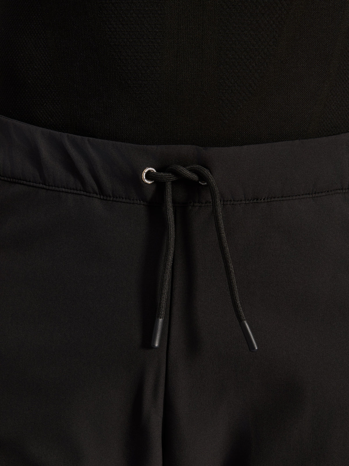 Alpinestars Aeroshell Airflow Hose, Schwarz, Nahaufnahme des Hosenbunds mit verstellbarem, internem elastischem Kordelzug und silbernen Ösen-Details, Sport-Touring-Motorradausrüstung