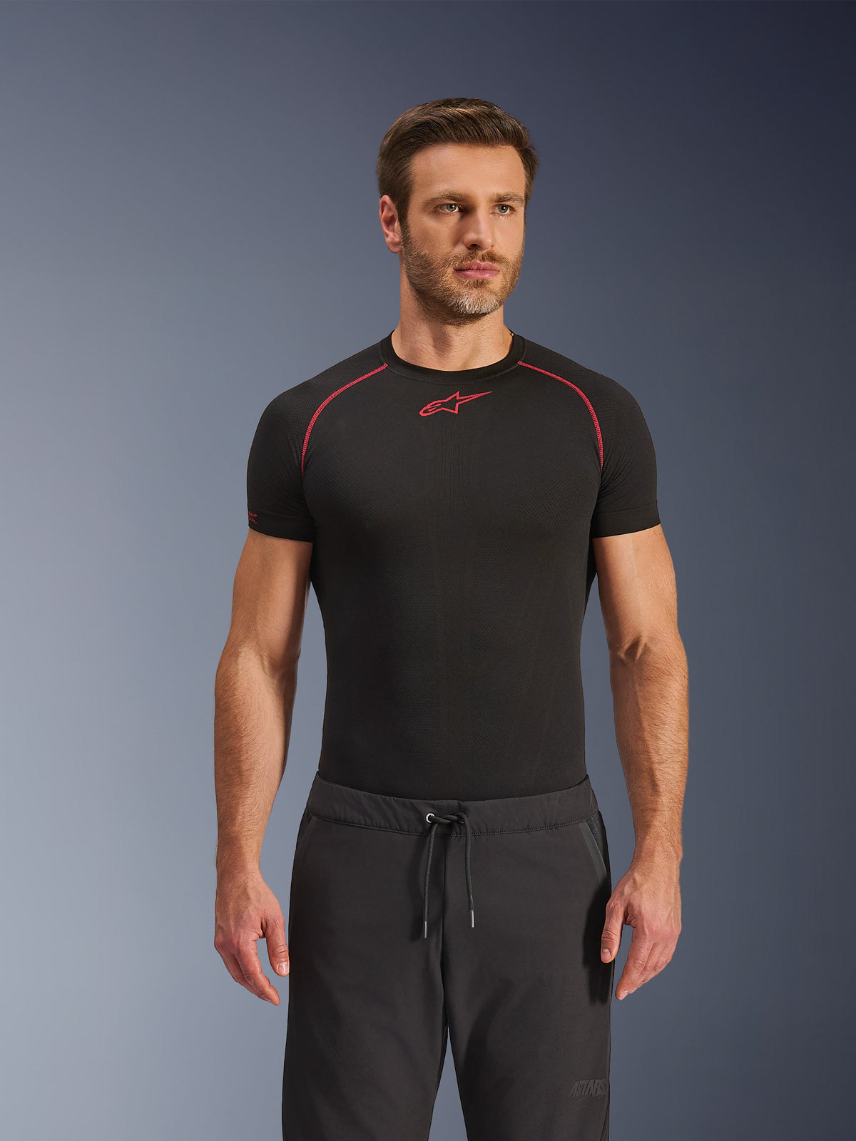 Alpinestars Aeroshell Airflow Hose, schwarze Motorradhose, leichtes Softshell-Gewebe, mit Kordelzug am Bund und laserperforierter Belüftung, getragen mit einem schwarzen Alpinestars Base-Layer-Shirt