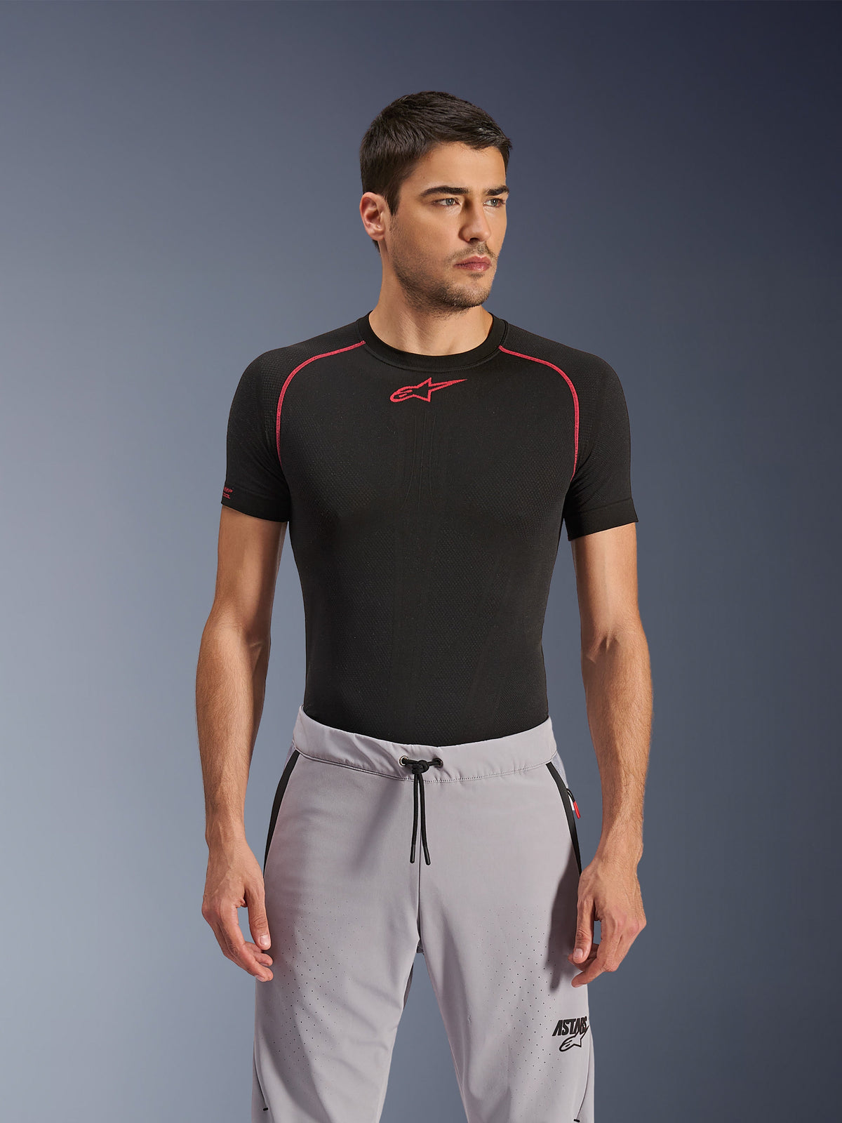 Pantalon Alpinestars Aeroshell Airflow, gris moyen, pantalon de moto porté avec une couche de base technique noire, doté de cuisses perforées au laser, d'une taille avec cordon de serrage et de poches zippées, style urbain sportif.