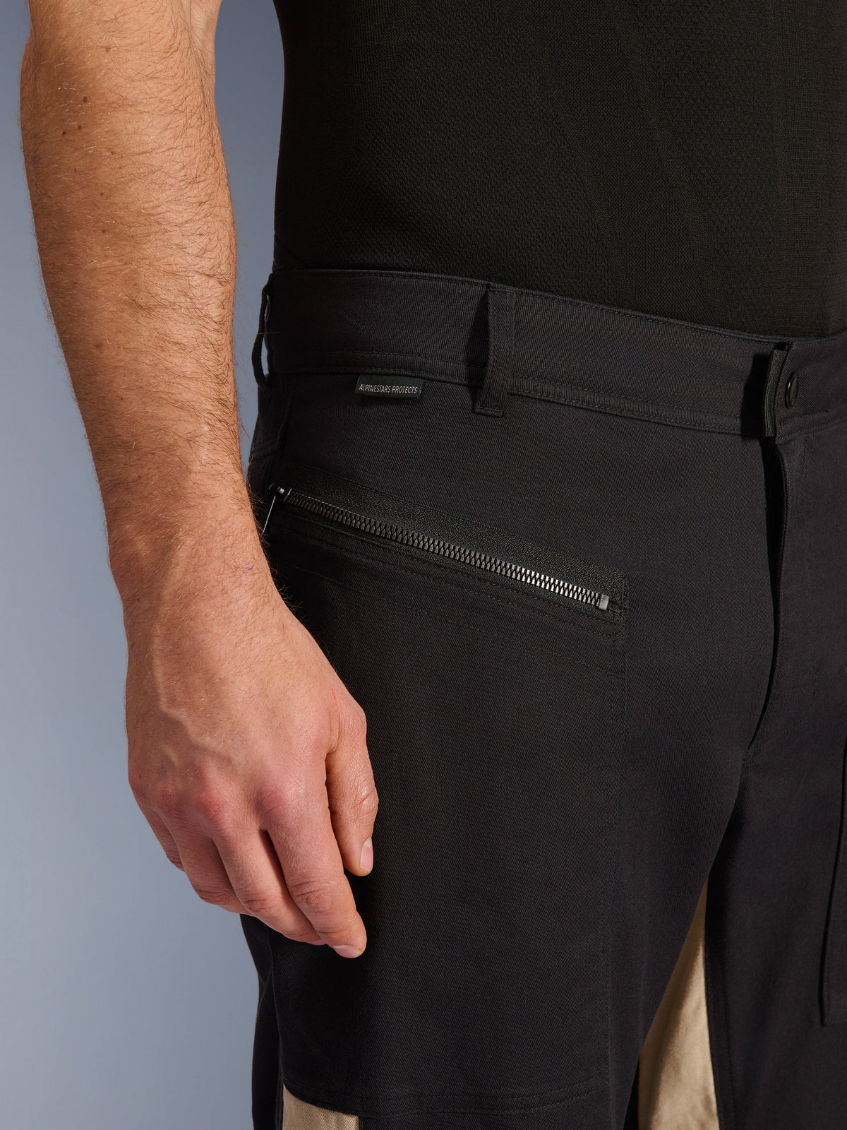 Pantalon Alpinestars Flex-AST Canvas en Black Aluminum, vue rapprochée de la zone des hanches avec une poche de conduite horizontale zippée, des passants de ceinture et une petite étiquette de marque, construction durable en polycoton extensible pour la conduite urbaine.
