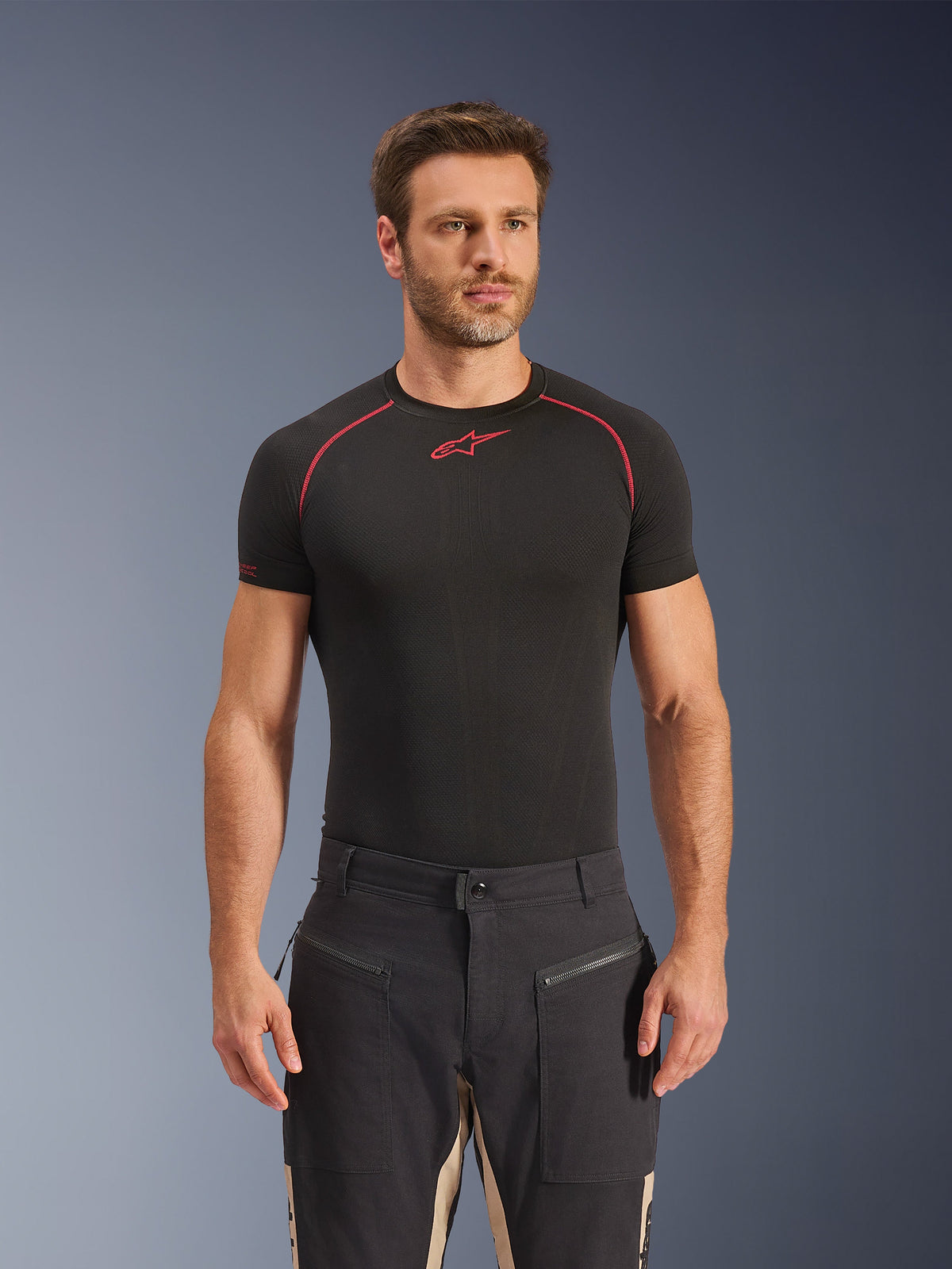 Pantalon Alpinestars Flex-AST Canvas en Black Aluminum, pantalon de moto urbain au design utilitaire workwear, avec poches avant zippées et empiècements contrastants beiges à l'intérieur des jambes, porté par un mannequin avec un t-shirt technique noir.