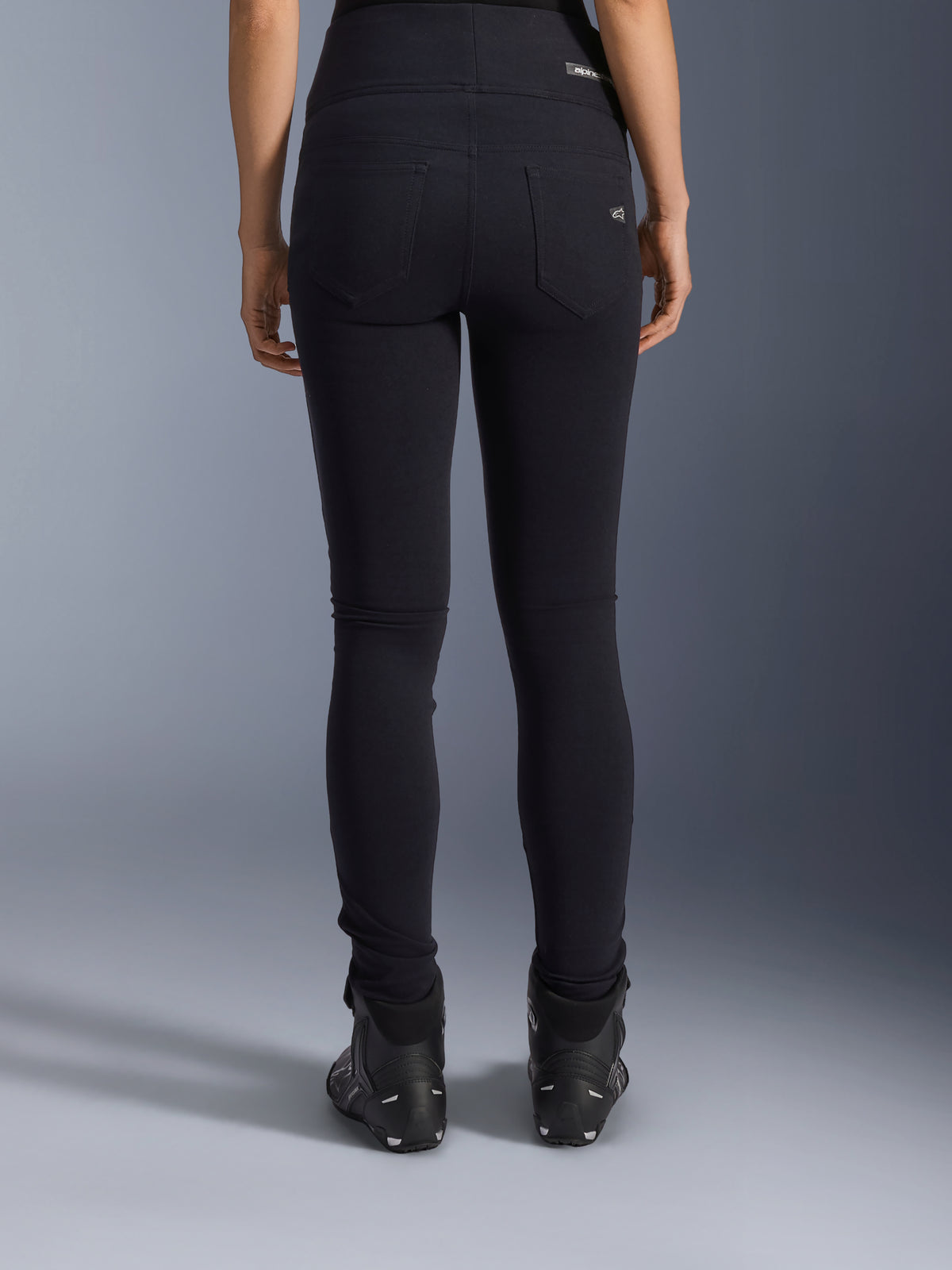 Alpinestars Stella Flex-Ast Leggings, dames motorlegging, zwart, achteraanzicht met achterzakken en slim fit pasvorm, gedragen met zwarte motorlaarzen, urban rijstijl
