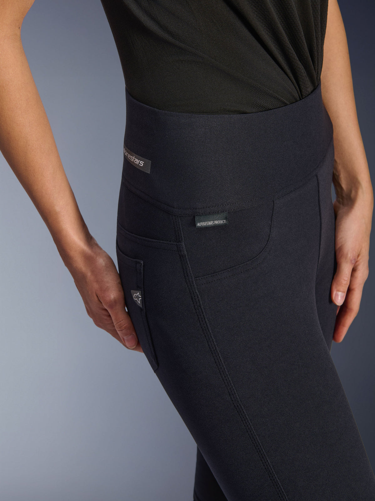 Alpinestars Stella Flex-Ast Leggings, motorlegging voor dames, zwart, close-up van de hoge tailleband en heupzone met subtiele merklogo's, strak stedelijk ontwerp voor op de weg