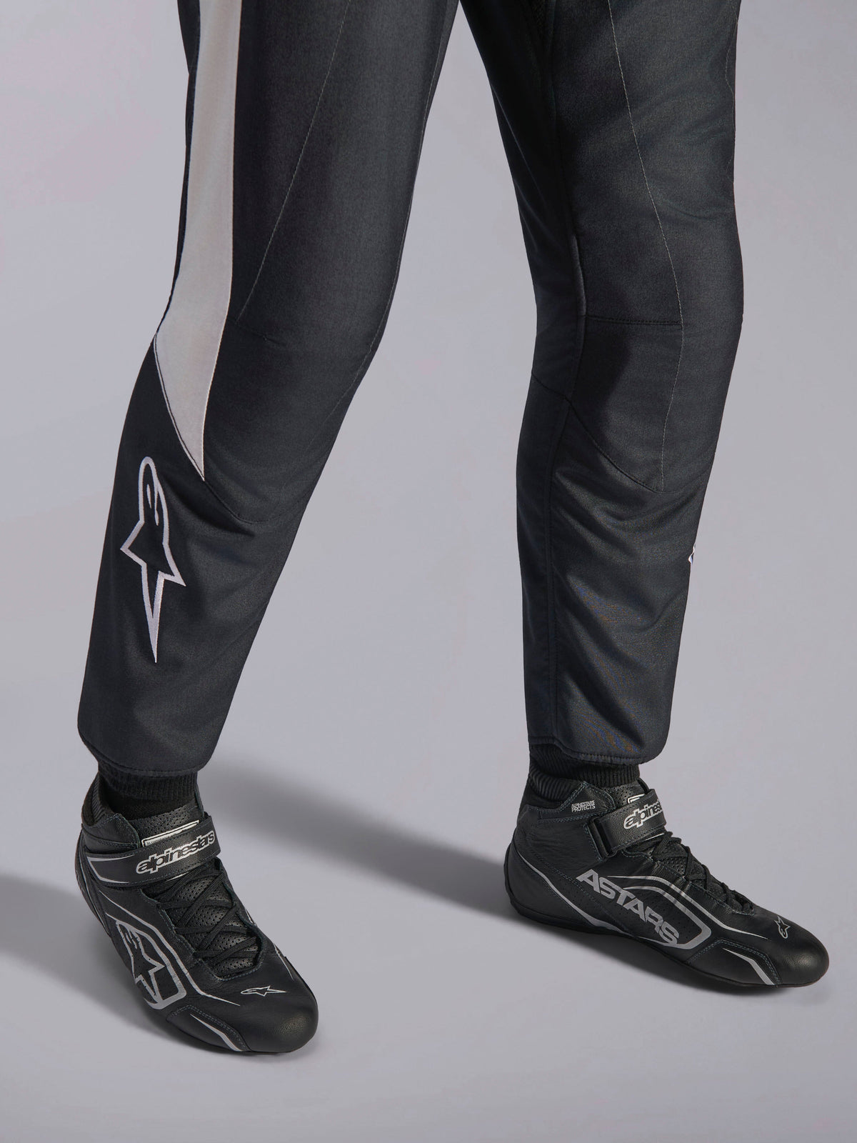 Combinaison Alpinestars GP Pro Comp V2 FIA, équipement auto noir et blanc et bottines de course professionnelles ASTARS.