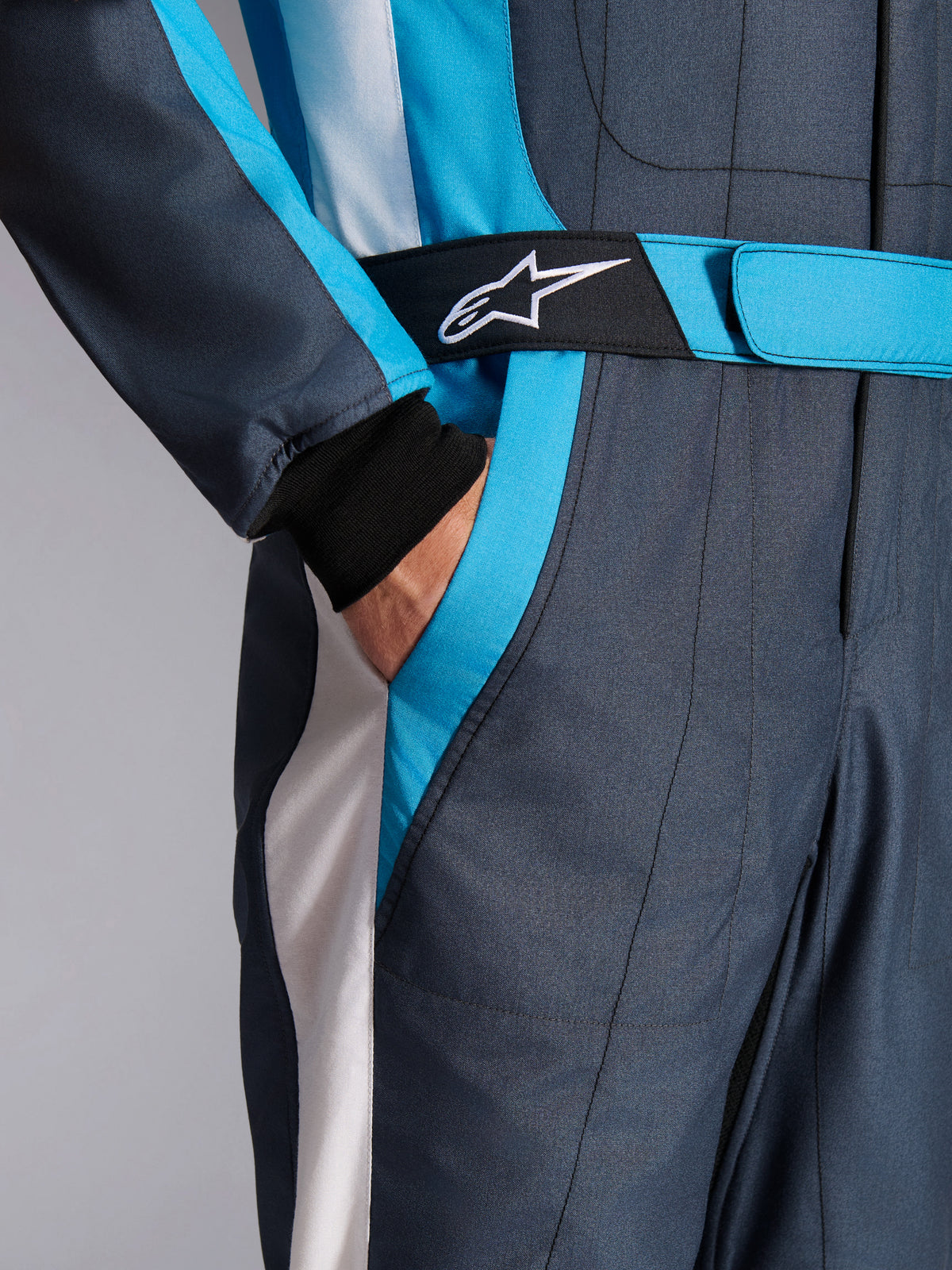 Alpinestars GP Pro Comp V2 FIA Rennanzug, Asphalt und Cyan, mit Logo-Hüftgurt und Seitentasche für den Autorennsport.