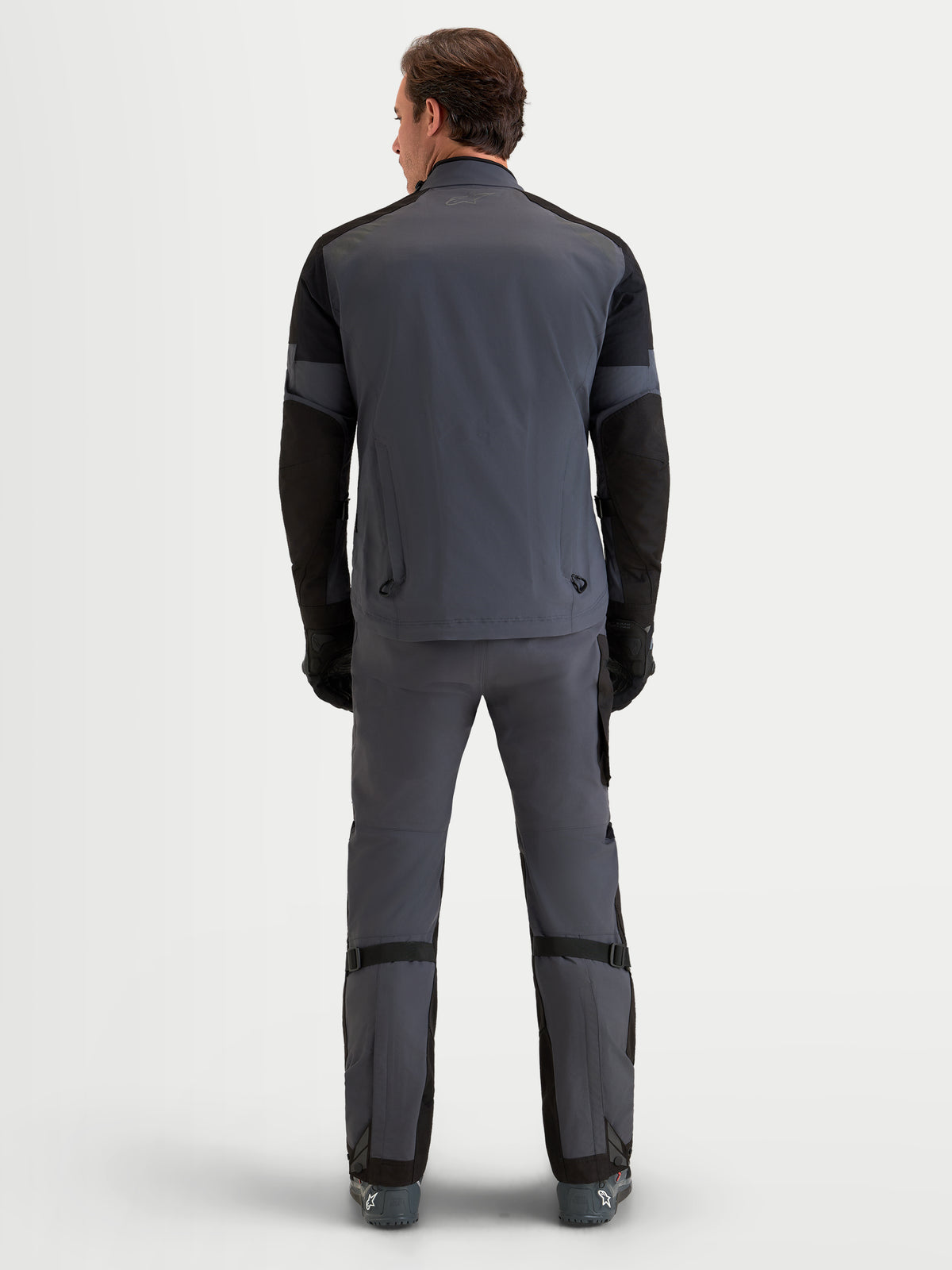 Alpinestars Arenis Gore-Tex Gear Set, heren adventure touring motorjas en motorbroek in grijs en zwart, achteraanzicht op een model in waterdichte all-terrain kleding