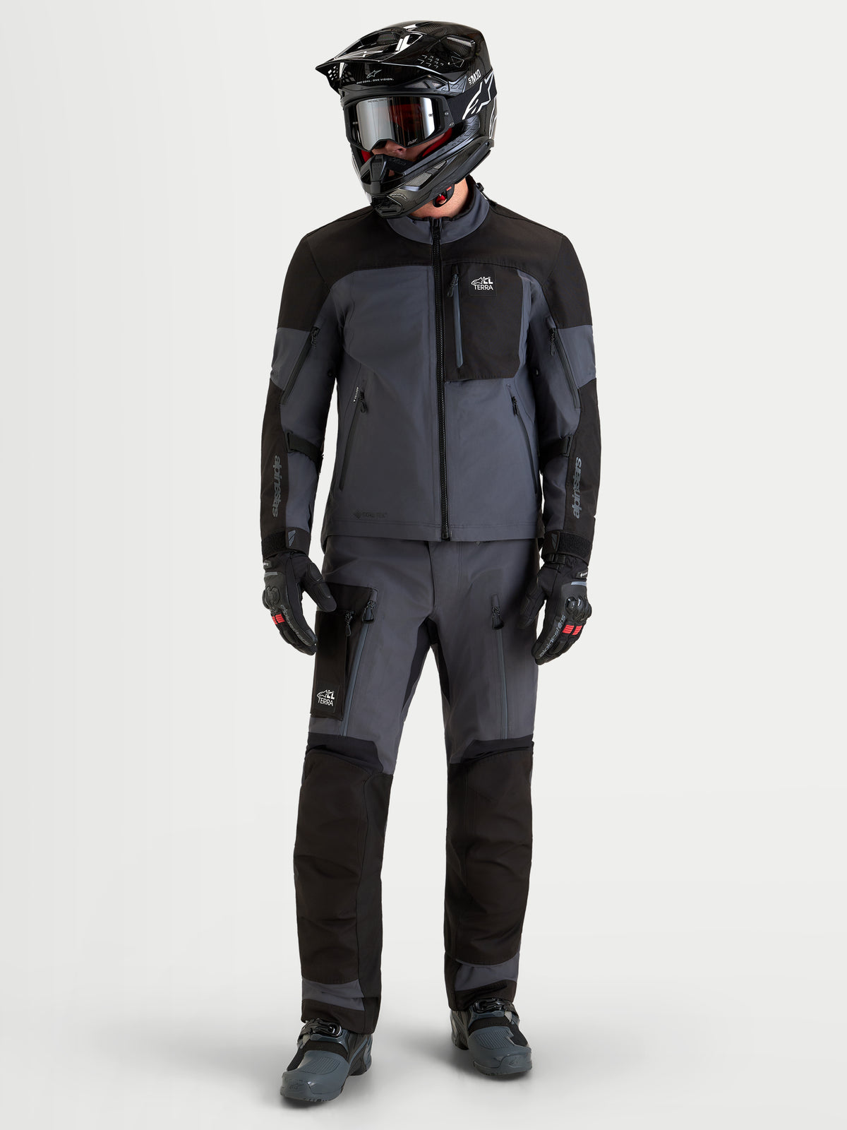 Alpinestars Arenis Gore-Tex Gear Set, heren adventure touring motorjas en motorbroek in zwart en donkergrijs, volledige studio weergave op een model met bijpassende uitrusting en helm, waterdichte all-terrain motorkleding