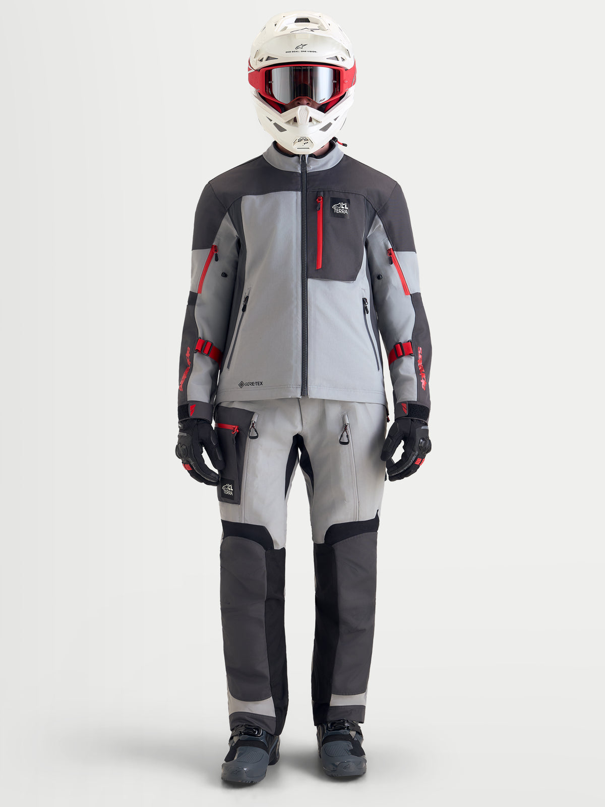 Alpinestars Arenis Gore-Tex jas, avontURENmotorjas voor heren in middenrijs, donkergrijs en zwart, afgebeeld op model in volledige avonturenuitrusting met helm en bijpassende broek