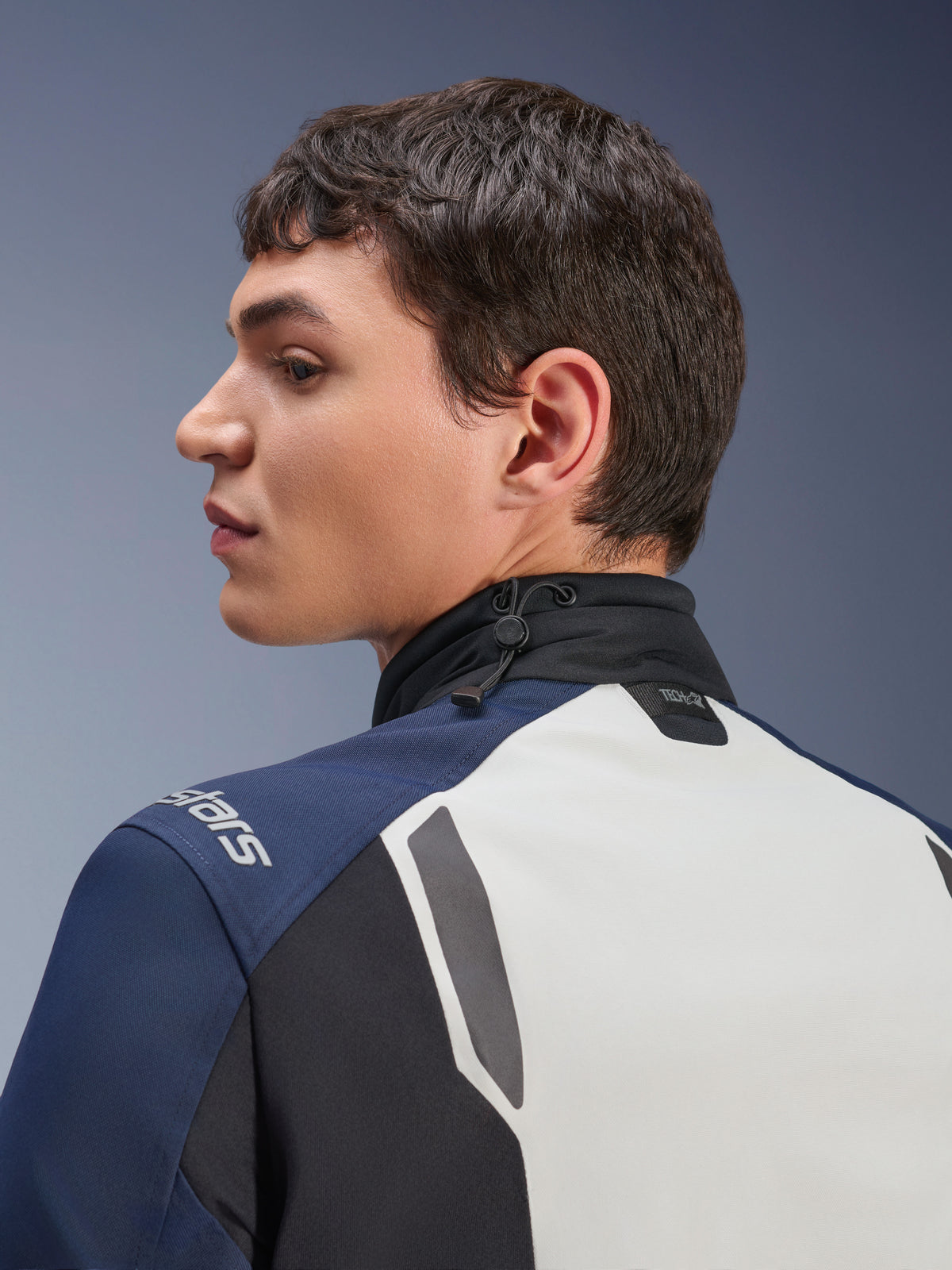 Alpinestars ST-7 2L GORE-TEX Jas, close-up profielaanzicht van de rug en nek, Ice Gray Dark Blue en Black, voorzien van een verstelbare kraag met schokkoord en Tech-Air branding, premium adventure touring motorjas.