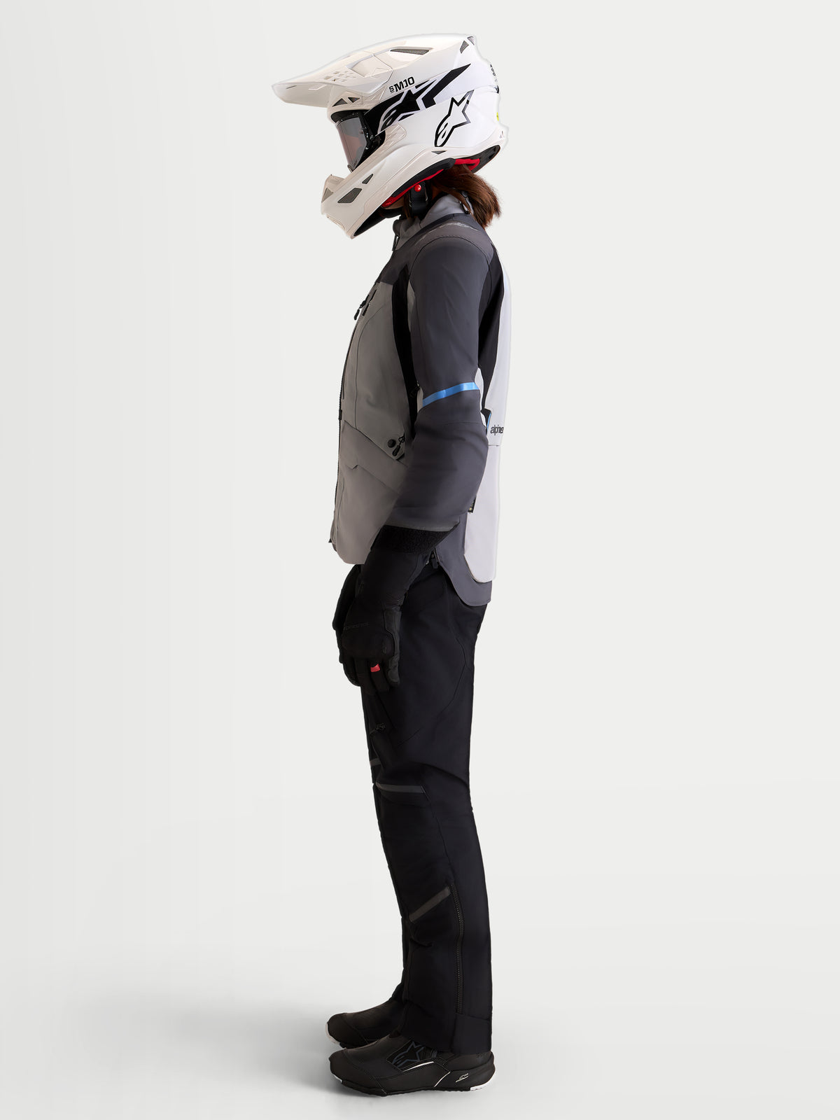 Alpinestars Stella ST-7 V2 2L Gore-Tex Veste, veste de moto adventure pour femme gris moyen, gris foncé et noir, vue de profil sur un modèle portant un casque assorti et un équipement de moto