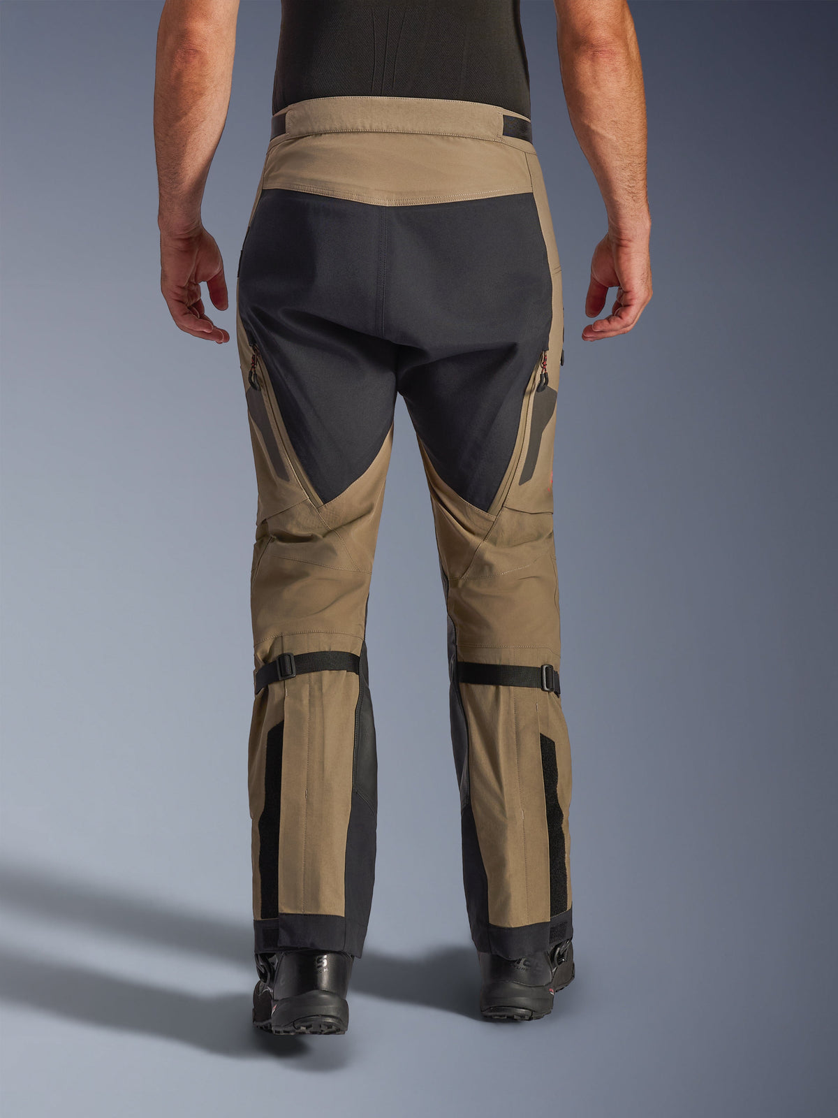 Pantalon Alpinestars Nazca 3L GORE-TEX PRO, Noyer et Noir, vue arrière montrant les ajusteurs de volume au mollet et les panneaux renforcés, pantalon de moto technique d'aventure pour rouler par tous les temps