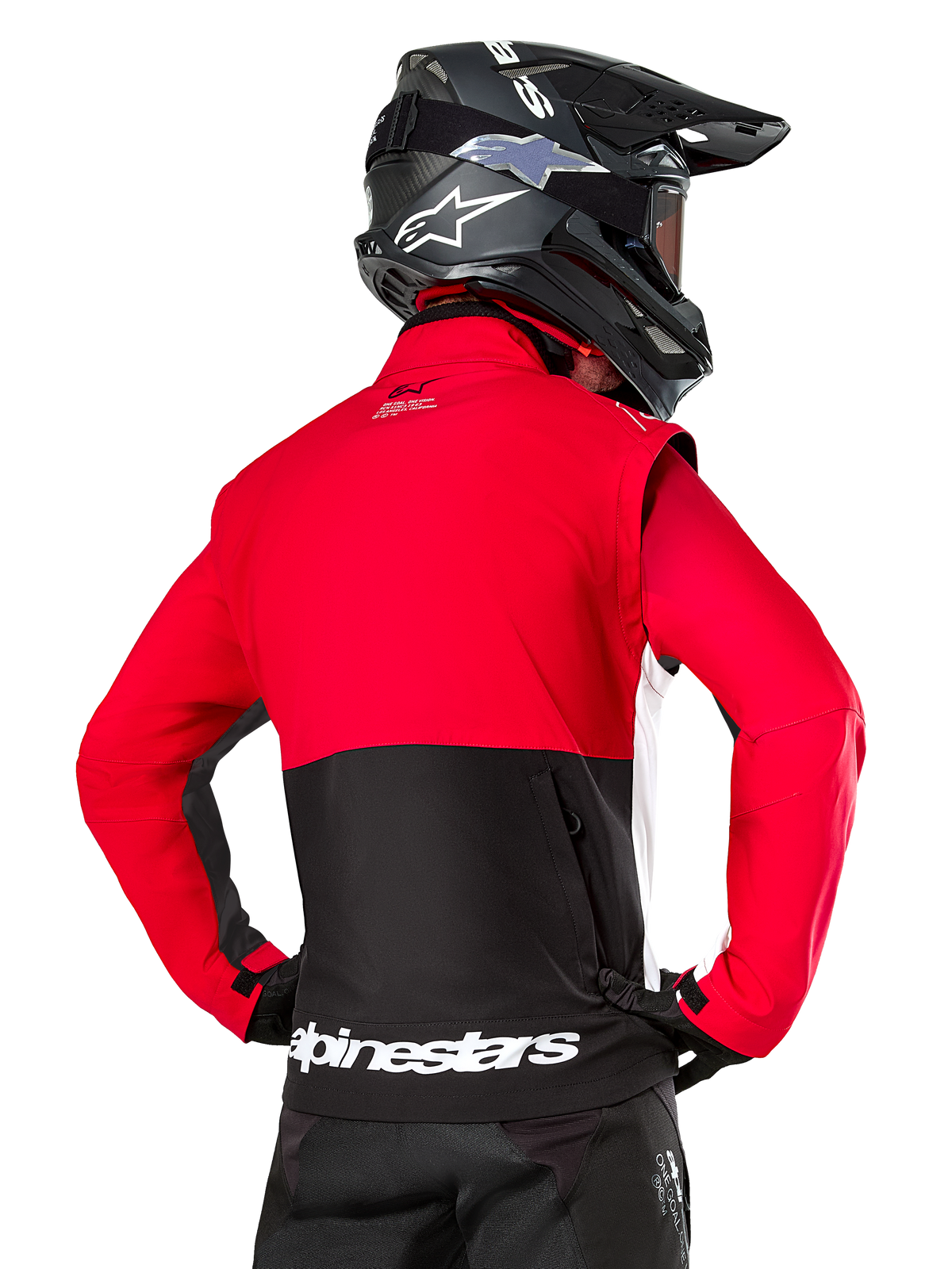 Alpinestars Pro-Dura jas, off-road enduro jas, rood en zwart met wit Alpinestars-logo op de achterzoom, van achteren gezien gedragen door een rijder met een zwarte motorcrosshelm, rally-geïnspireerd ontwerp voor agressief trailrijden