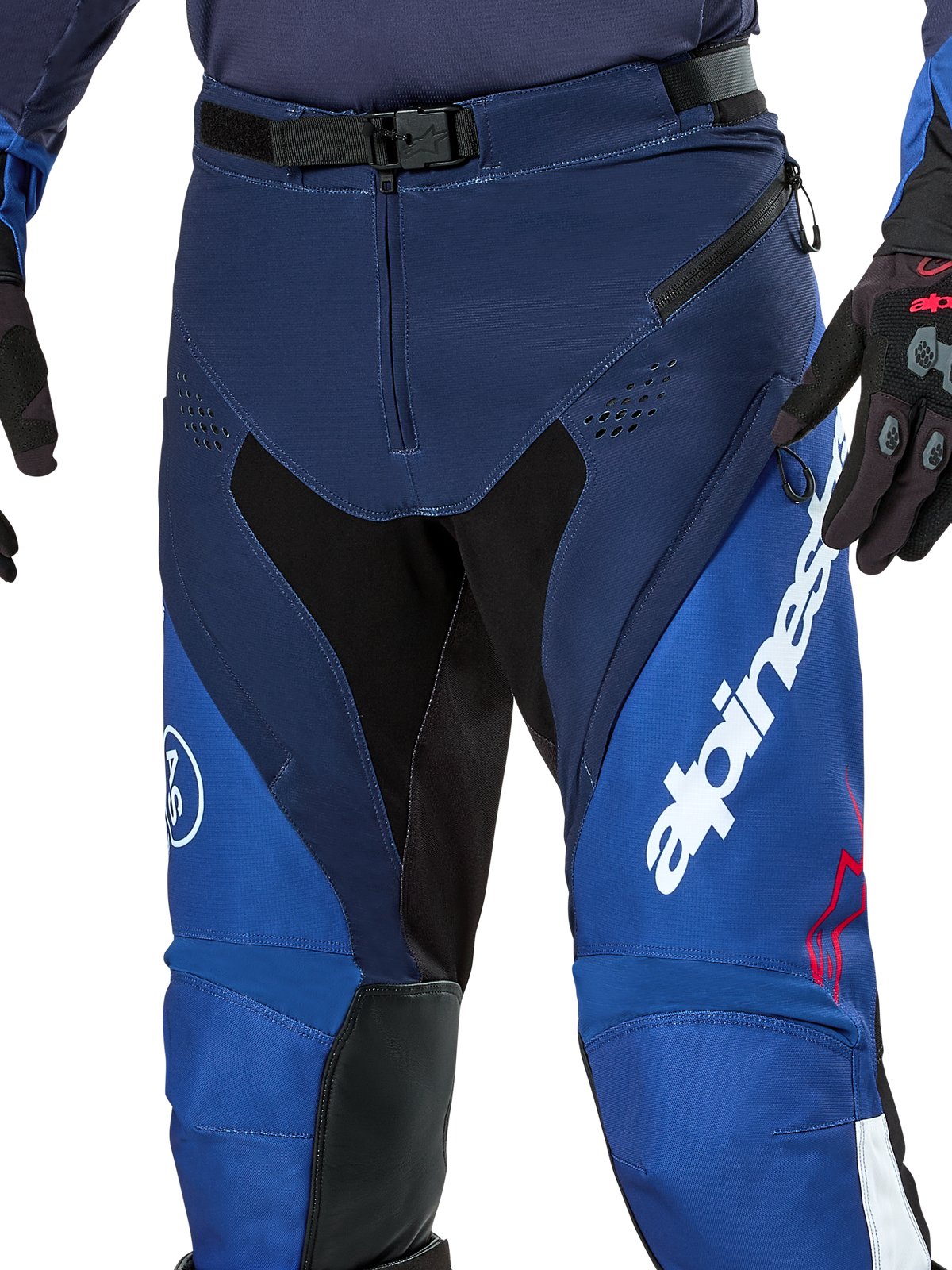 Pantalon Alpinestars Pro-Dura, pantalon d'enduro et de motocross, bleu marine, bleu vif et blanc, vue rapprochée montrant la fermeture de la taille par boucle magnétique SX2, les ventilations zippées sur les cuisses et les panneaux extensibles durables avec un marquage blanc imposant.