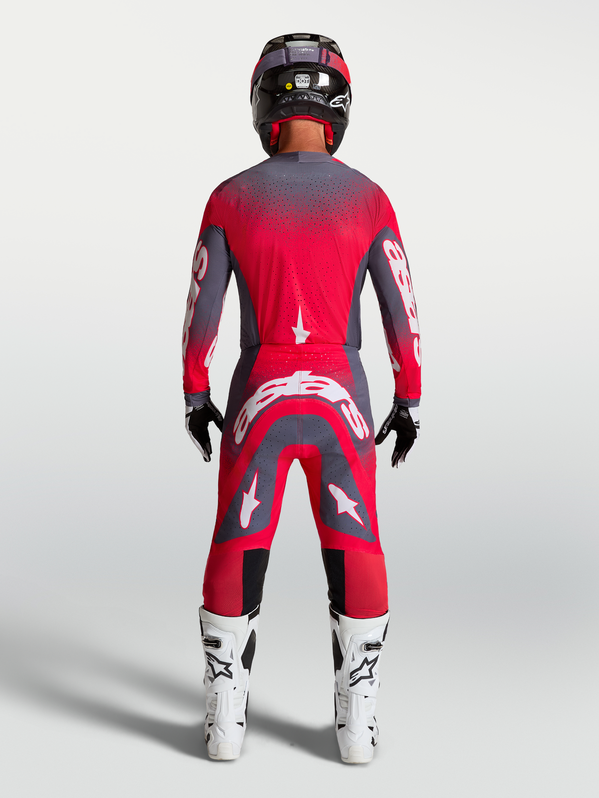 Alpinestars Supertech Hiten AFD gearset en broek, motocross racinguitrusting in neonrood en grijs, achteraanzicht op model.