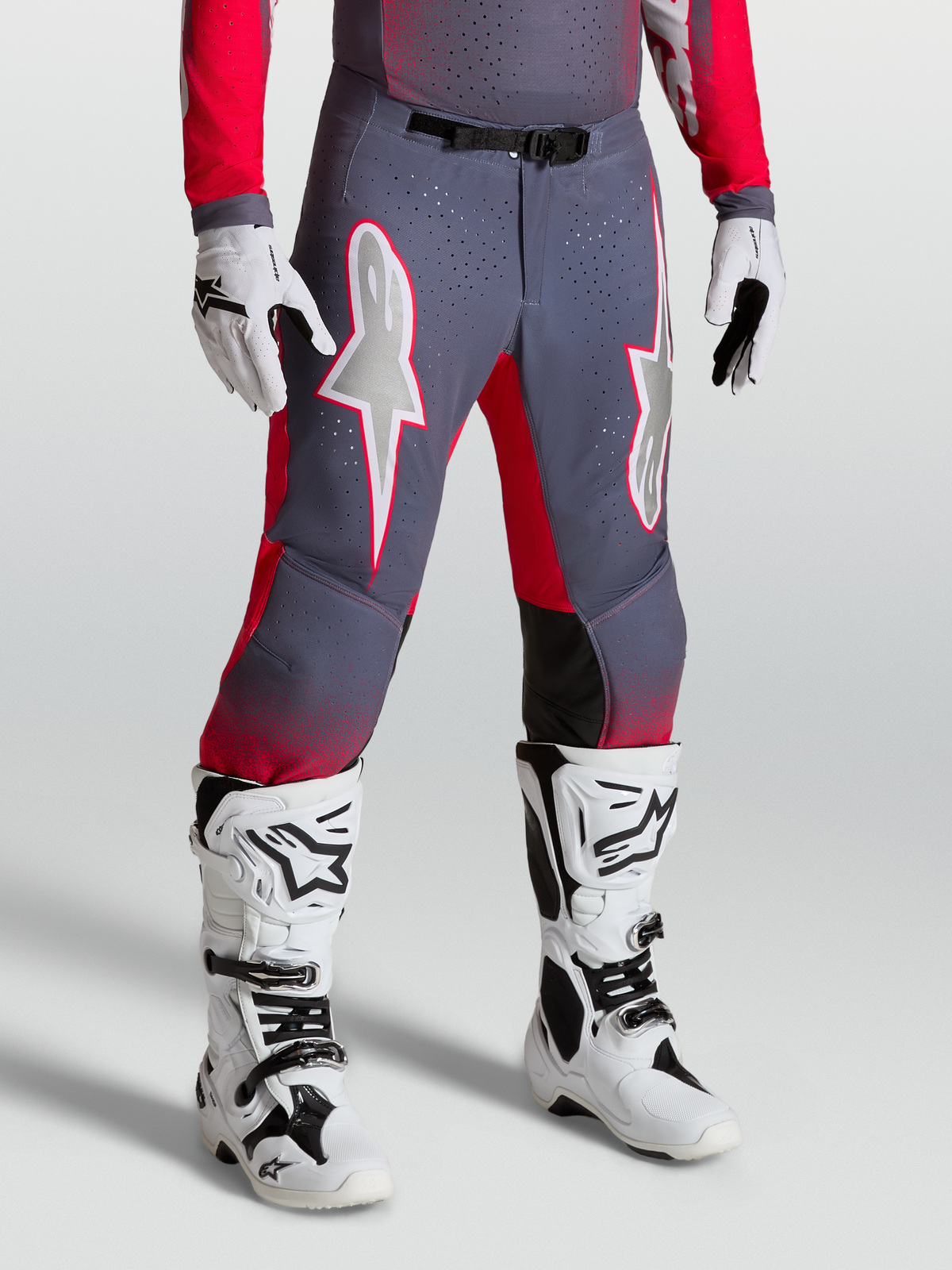 Alpinestars Supertech Hiten AFD broek, motocrossbroek in grijs en rood met witte ster-graphics en magnetische gesp.