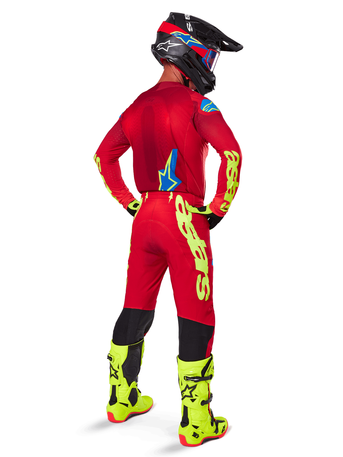 Alpinestars 2025 Supertech Maker Pants, Motocross Pants, Bright Red and Yellow Fluo, seen from behind on a rider wearing a matching red jersey, fluorescent yellow boots, and black helmet, featuring large yellow Alpinestars branding on the leg.