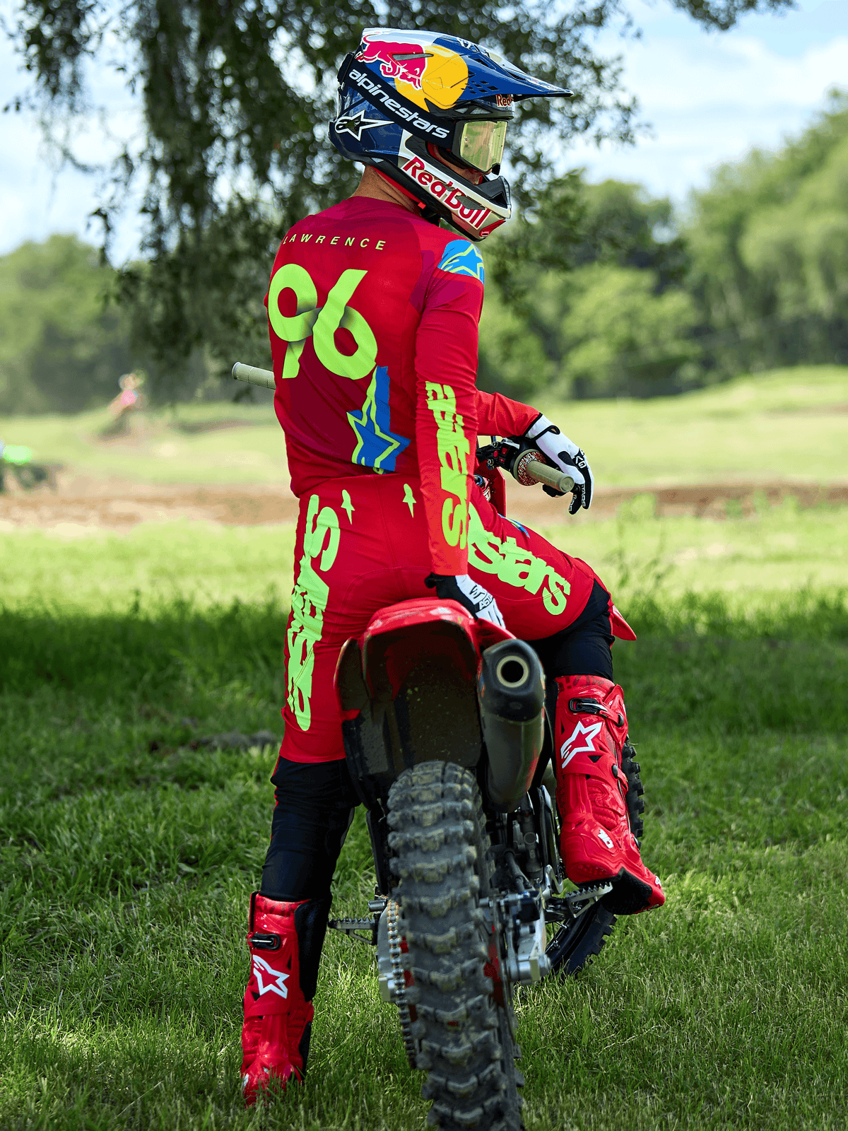Motocross rider wearing the Alpinestars 2025 Supertech Maker Gear Set in Bright Red and Yellow Fluo, sitting on a red dirt bike, featuring jersey number 96, matching red boots and helmet, professional racing gear for off-road performance