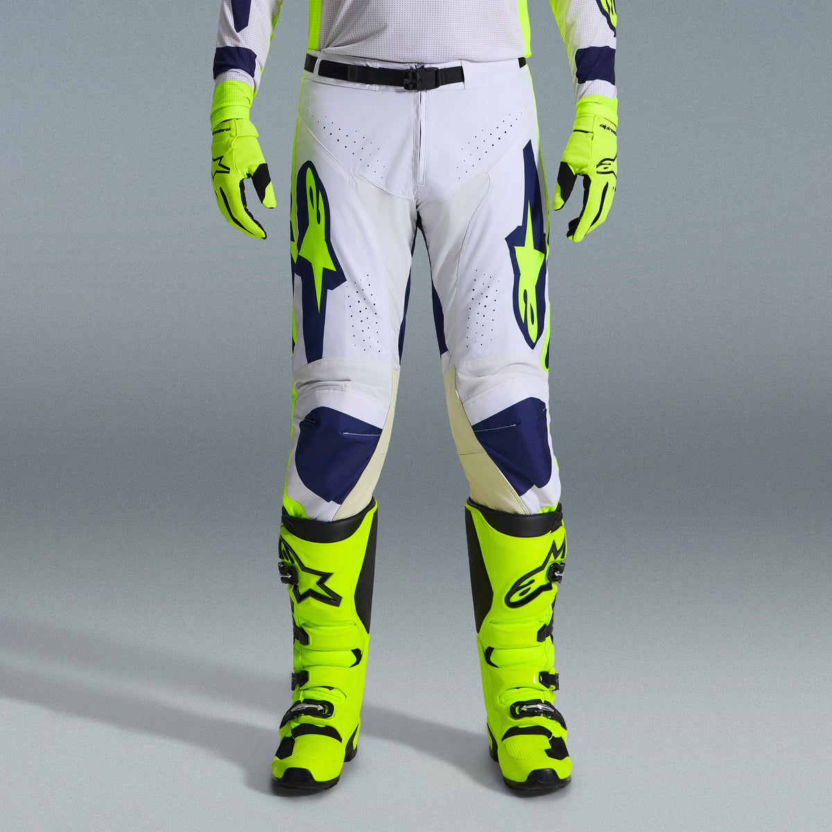 Alpinestars 2026 Racer Air Riway Bekleidungsset, Motocross-Hose in Weiß und Marineblau mit neongelben Akzenten, kombiniert mit passenden neongelben Handschuhen und Stiefeln, mit ergonomischem Design und belüfteten Einsätzen für den Offroad-Rennsport.
