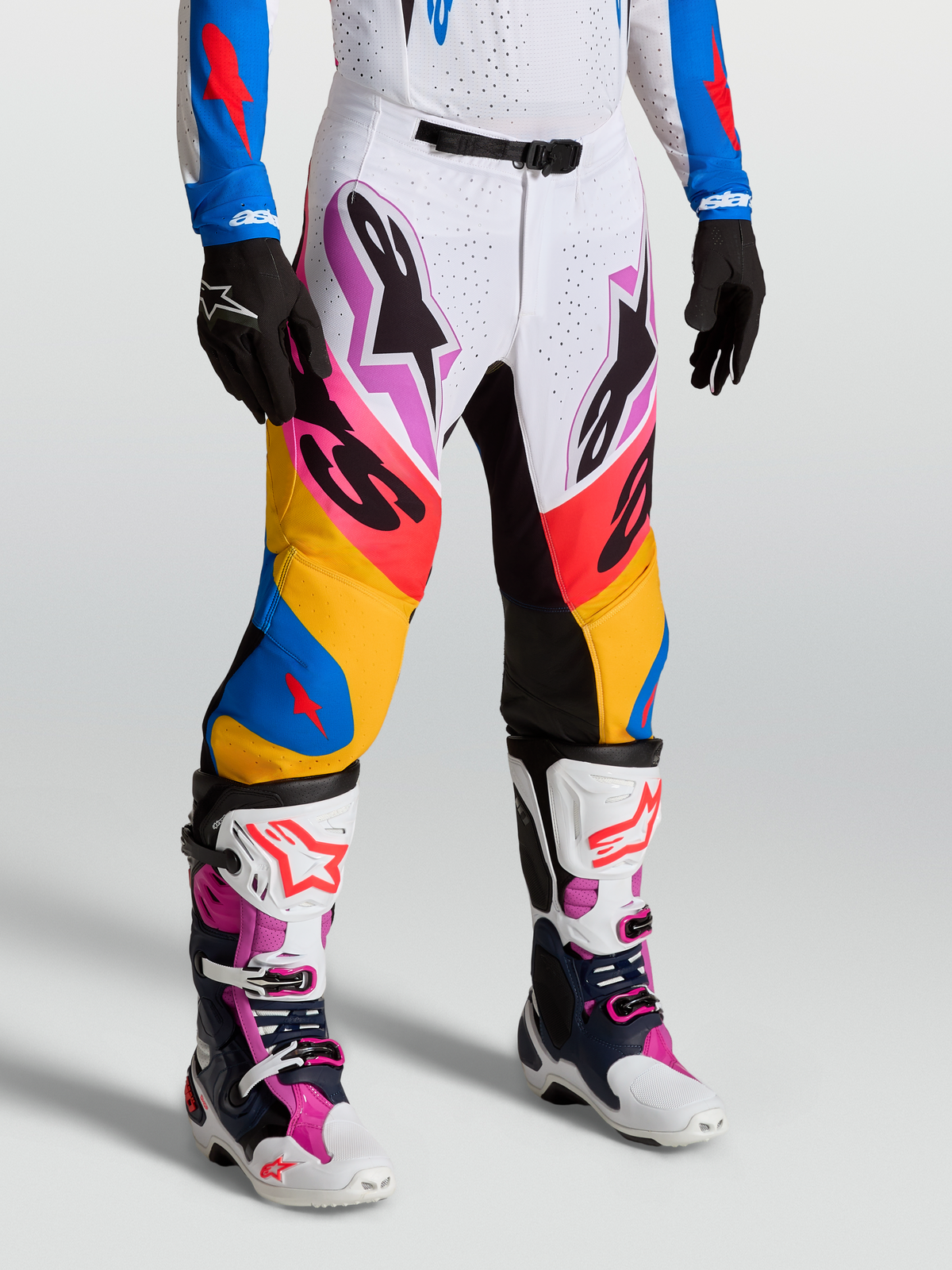 Alpinestars Supertech Dyna Motocross-Hosen am Model, Weiß und Blau, Stretch-Ripstop-Gewebe und Ziegenleder-Kniepaneele.