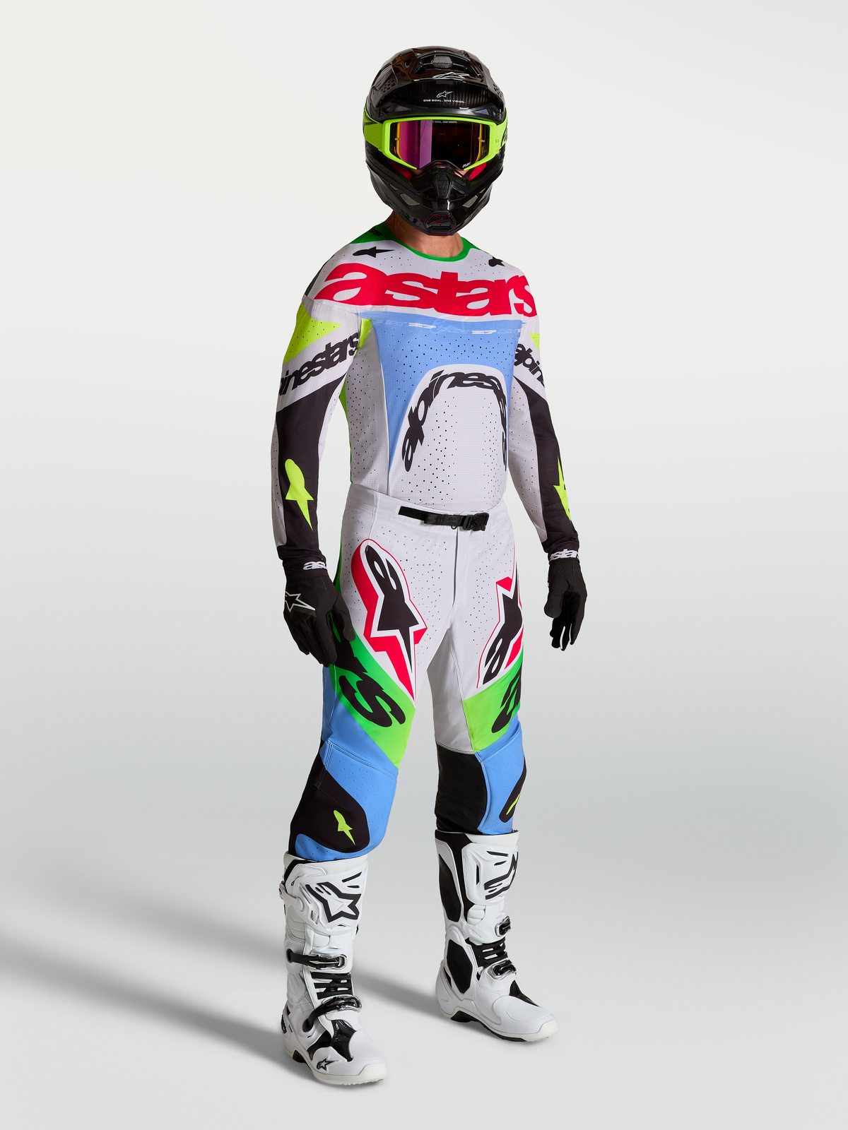 Pantalon Alpinestars Supertech Dyna, tenue de motocross homme, lilas clair et vert fluo, porté avec un kit de course complet.