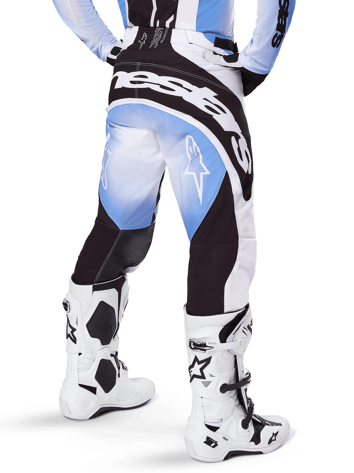 Alpinestars 2025 Techstar Melt Hose, Motocross-Hose, Schwarz, Blau und Weiß, Rückansicht mit markantem Alpinestars-Schriftzug am Gesäß und Stern-Logos auf den Beinen, kombiniert mit weiß-schwarzen Tech 10 Stiefeln, professionelle Offroad-Rennausrüstung