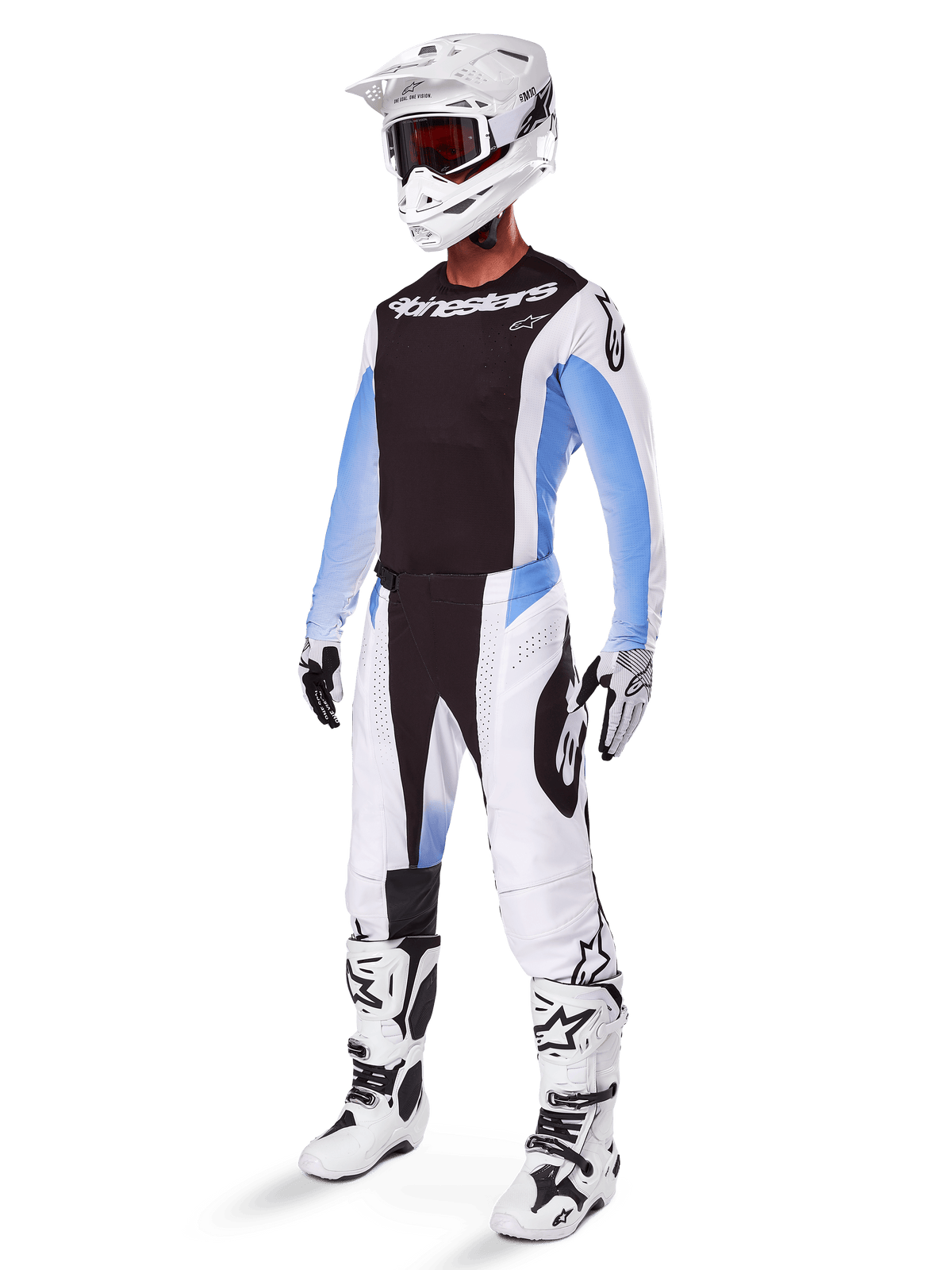 Pilote de motocross portant le pantalon Alpinestars Techstar Melt 2025, tenue de motocross blanche et noire avec des accents bleu clair, maillot et gants coordonnés, casque et lunettes blancs, bottes de course blanches et noires, équipement tout-terrain professionnel.