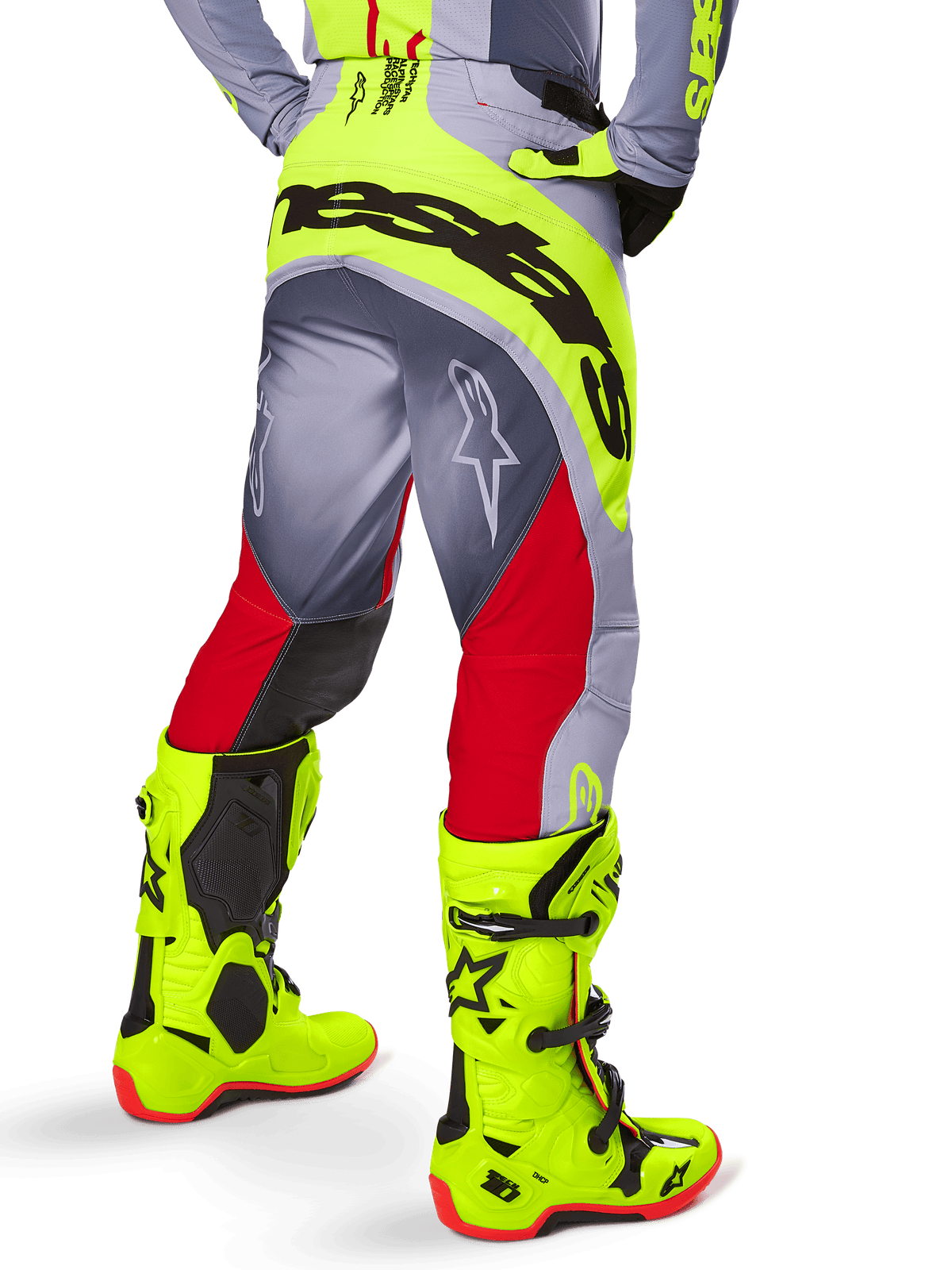 Alpinestars 2025 Techstar Melt Hose, Motocross-Hose, Hellrot und Grau mit neongelben Akzenten, Rückansicht mit großem schwarzem Branding am Gesäß, getragen mit passenden leuchtend gelben Stiefeln und einem grauen Trikot, athletische Rennpassform für Offroad-Wettbewerbe.