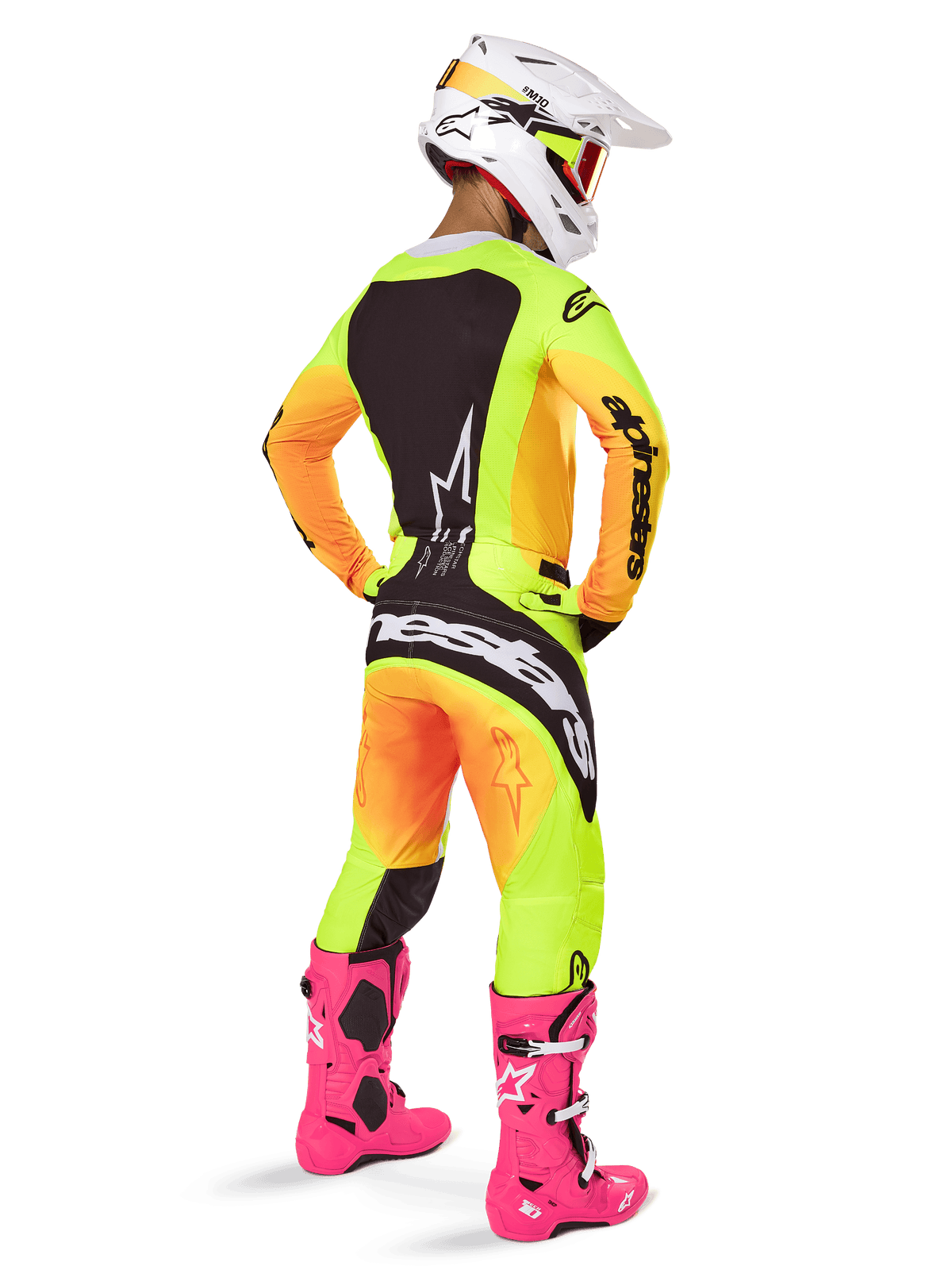 Motocross-Fahrer von hinten in der Alpinestars 2025 Techstar Melt Ausrüstung, Trikot und Hose mit gelb-orangefarbenem Farbverlauf und schwarzen Einsätzen, weißer Helm mit roter Brille, leuchtend rosa Stiefel, abgestimmtes Rennoutfit für Offroad-Performance