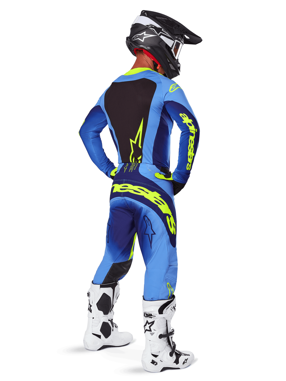 Alpinestars 2025 Techstar Melt crossbroek, motorcross kleding, Yellow Fluo Blue, achteraanzicht van een rijder met bijpassende blauwe jersey met opvallende gele branding, witte en zwarte laarzen en zwarte helm, complete race-outfit voor off-road prestaties