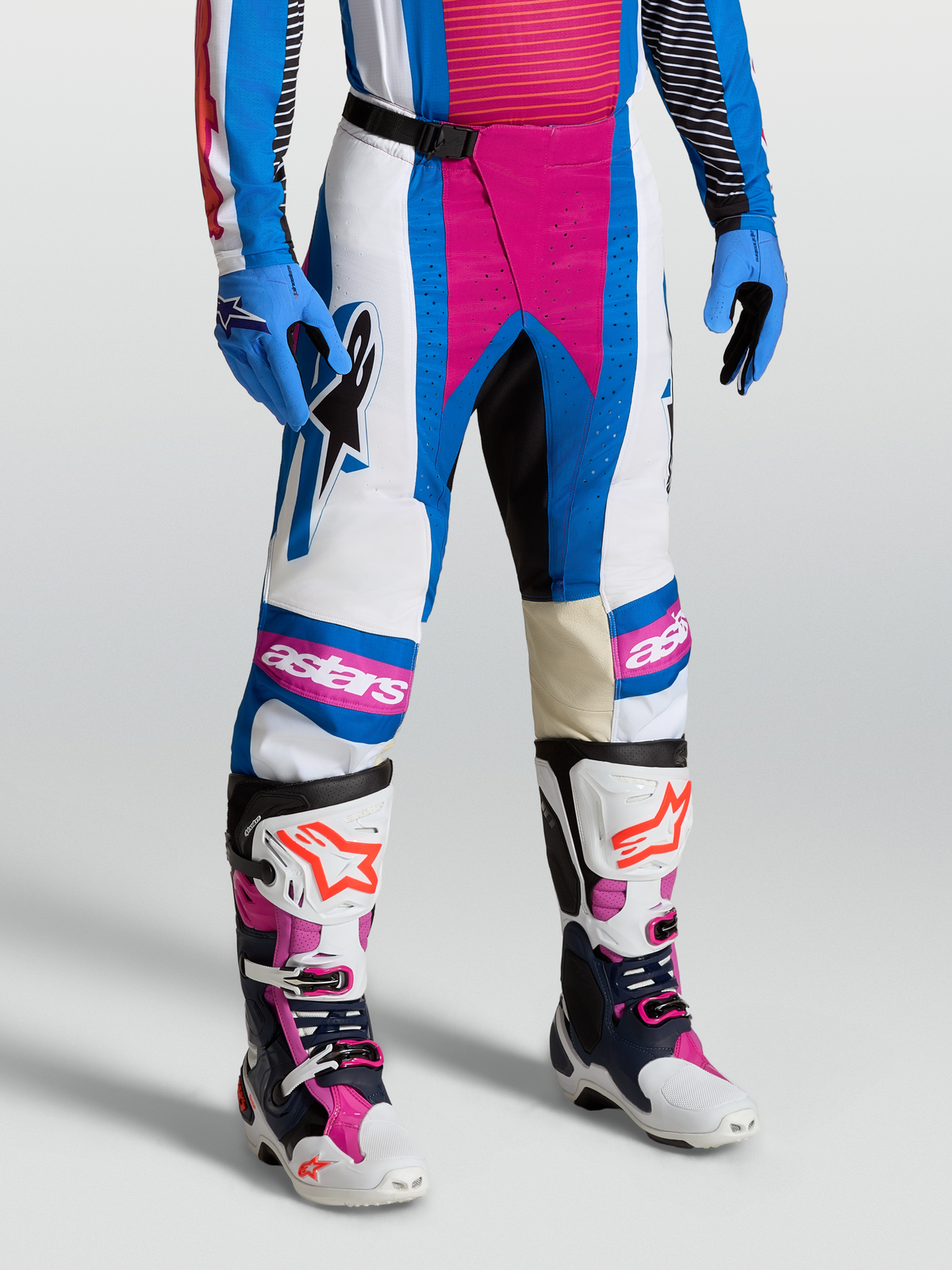 Alpinestars Techstar Maven, pantalon de motocross pour homme, blanc et rose corail, porté avec des bottes et des gants assortis, équipement tout-terrain performant