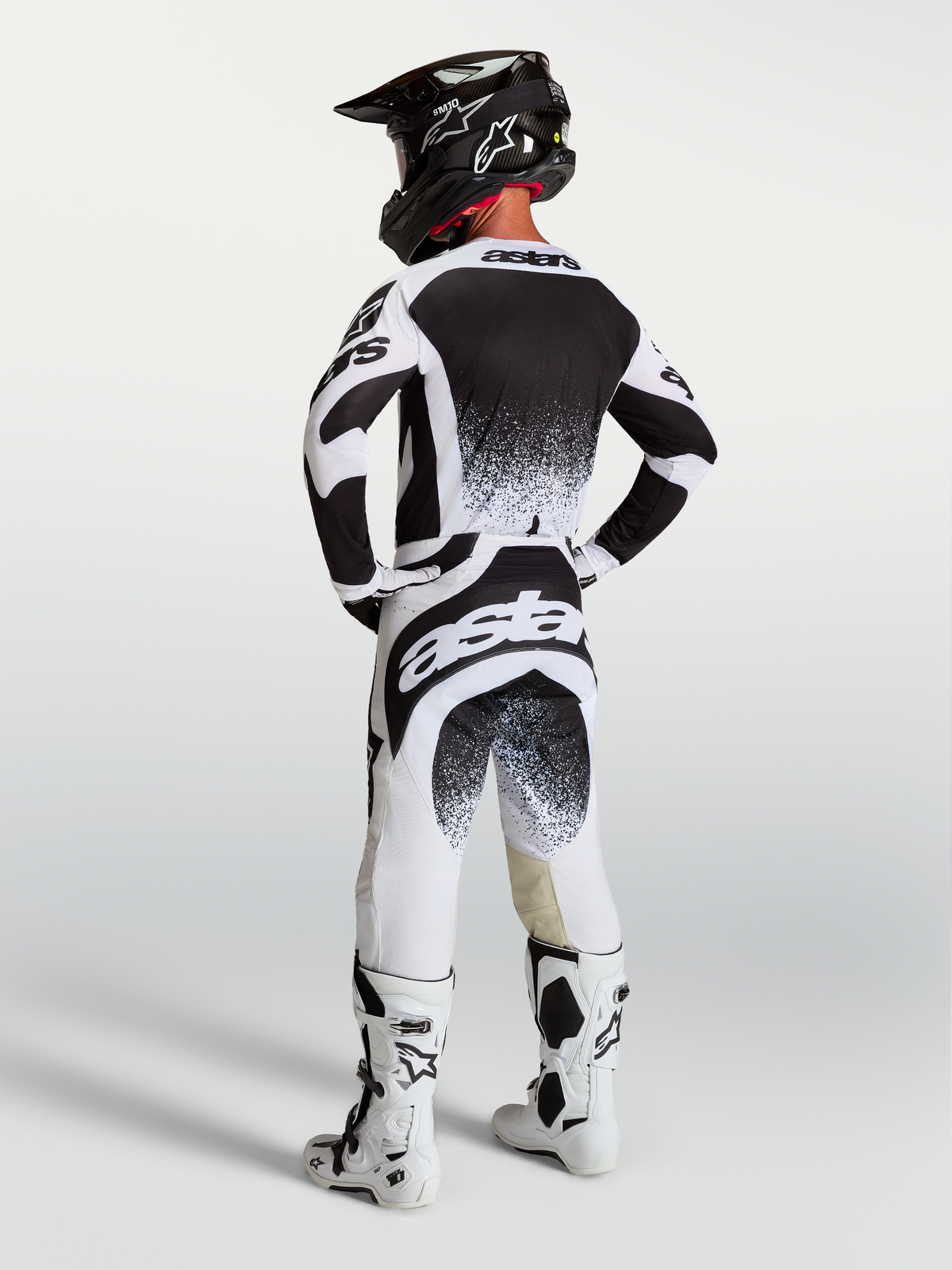 Alpinestars 2027 Techstar Swan Pants and Jersey, Black and White Motocross Racing Gear, back view of rider in full kit.