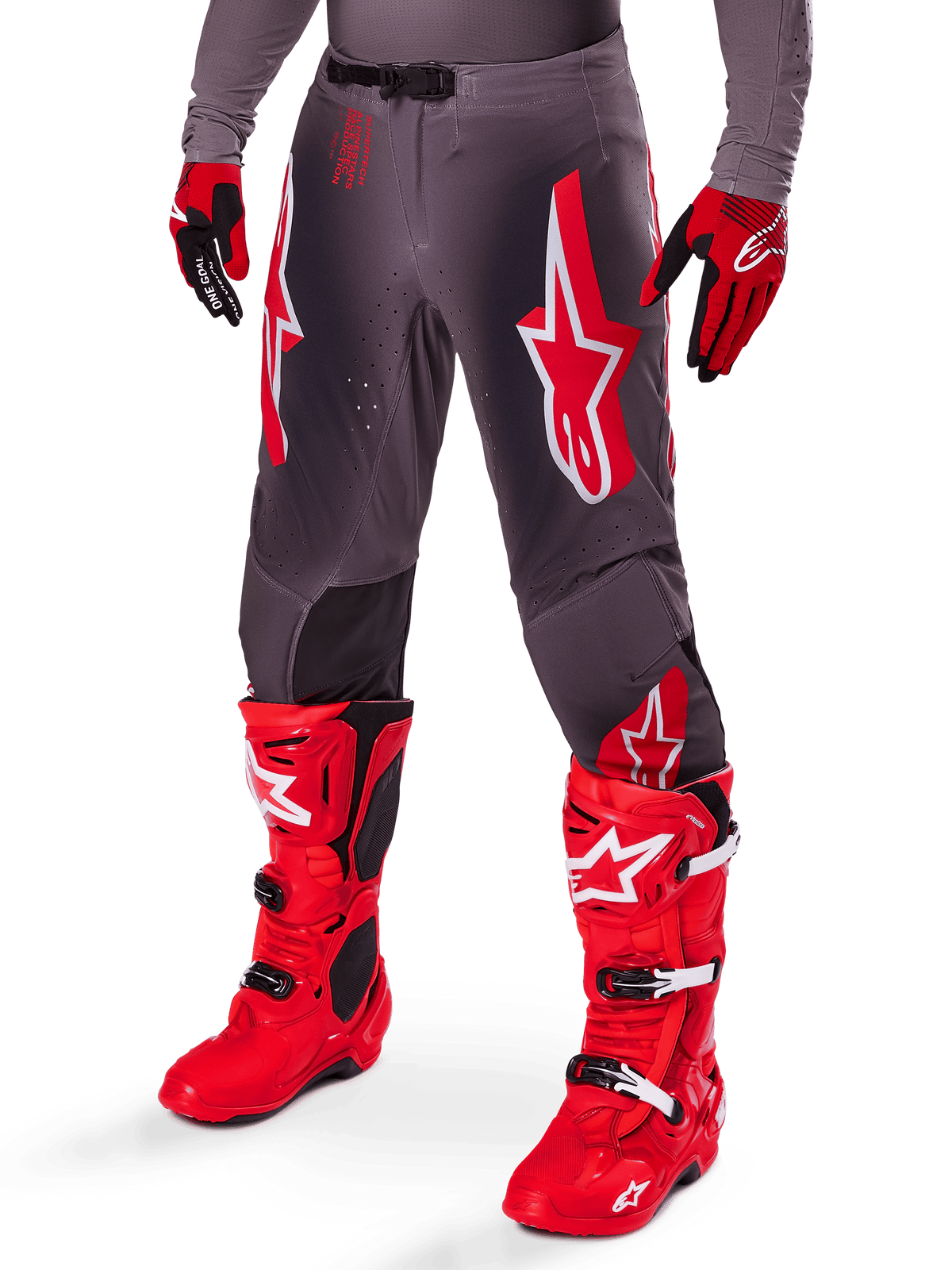 Alpinestars 2025 Supertech Lipan Gear Set, grijze motocrossbroek met opvallende rode en witte sterlogo's, gecombineerd met felrode performance-laarzen en rood-zwarte handschoenen, ontworpen voor professioneel racen
